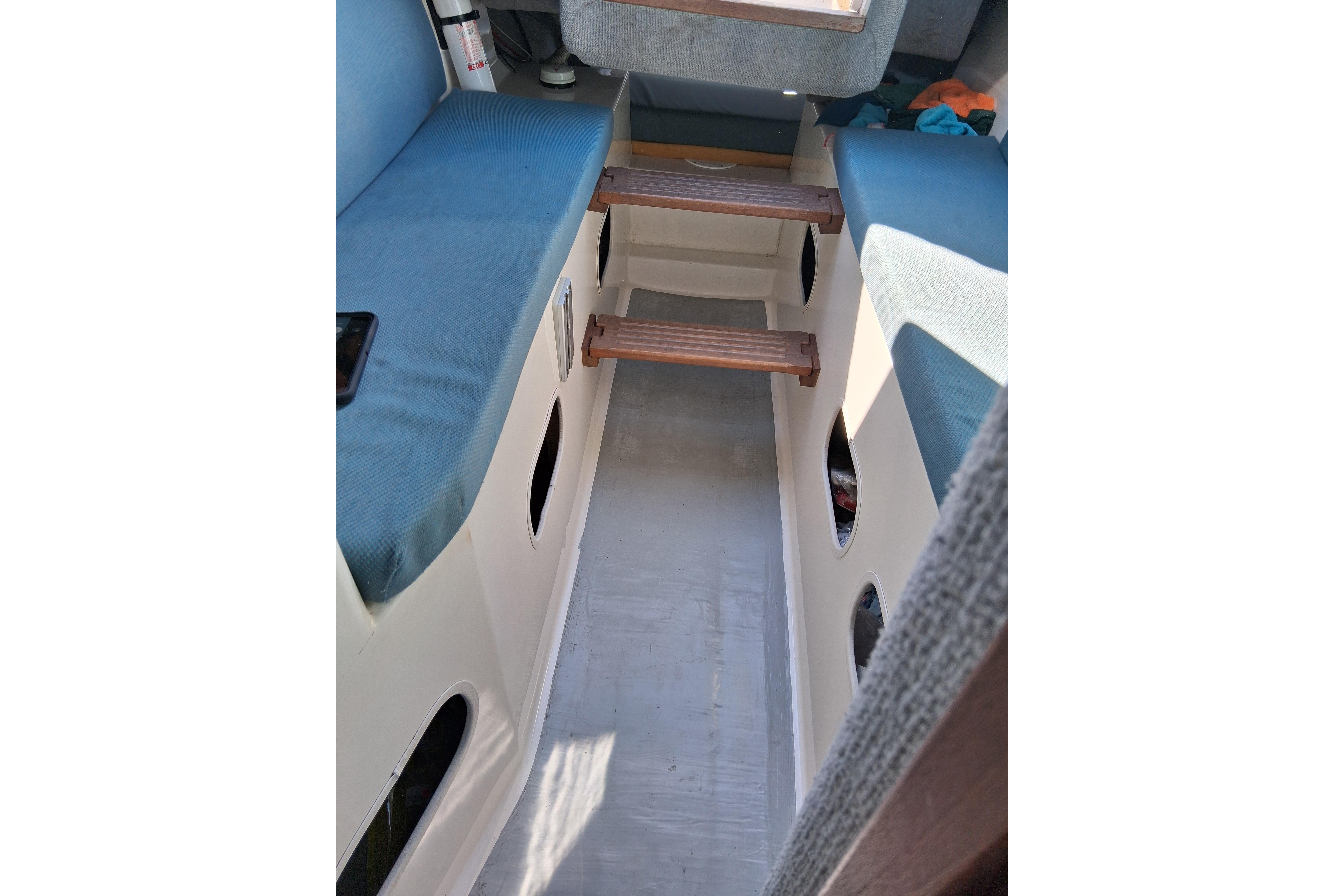 Interior of a 2000 Farrier 31 boat with blue seating and wooden steps.
