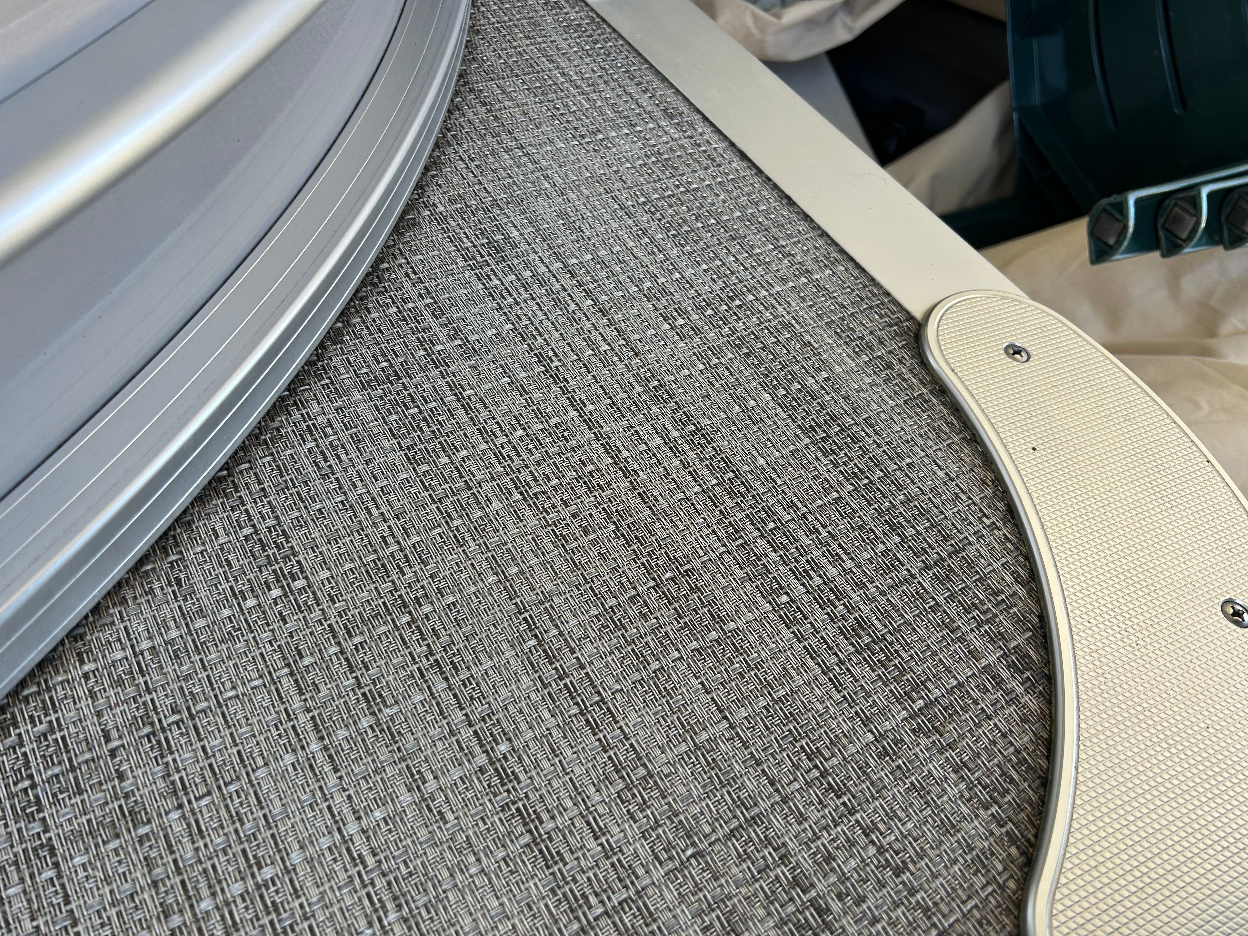 Close-up of a boat deck with textured flooring and metal framing.