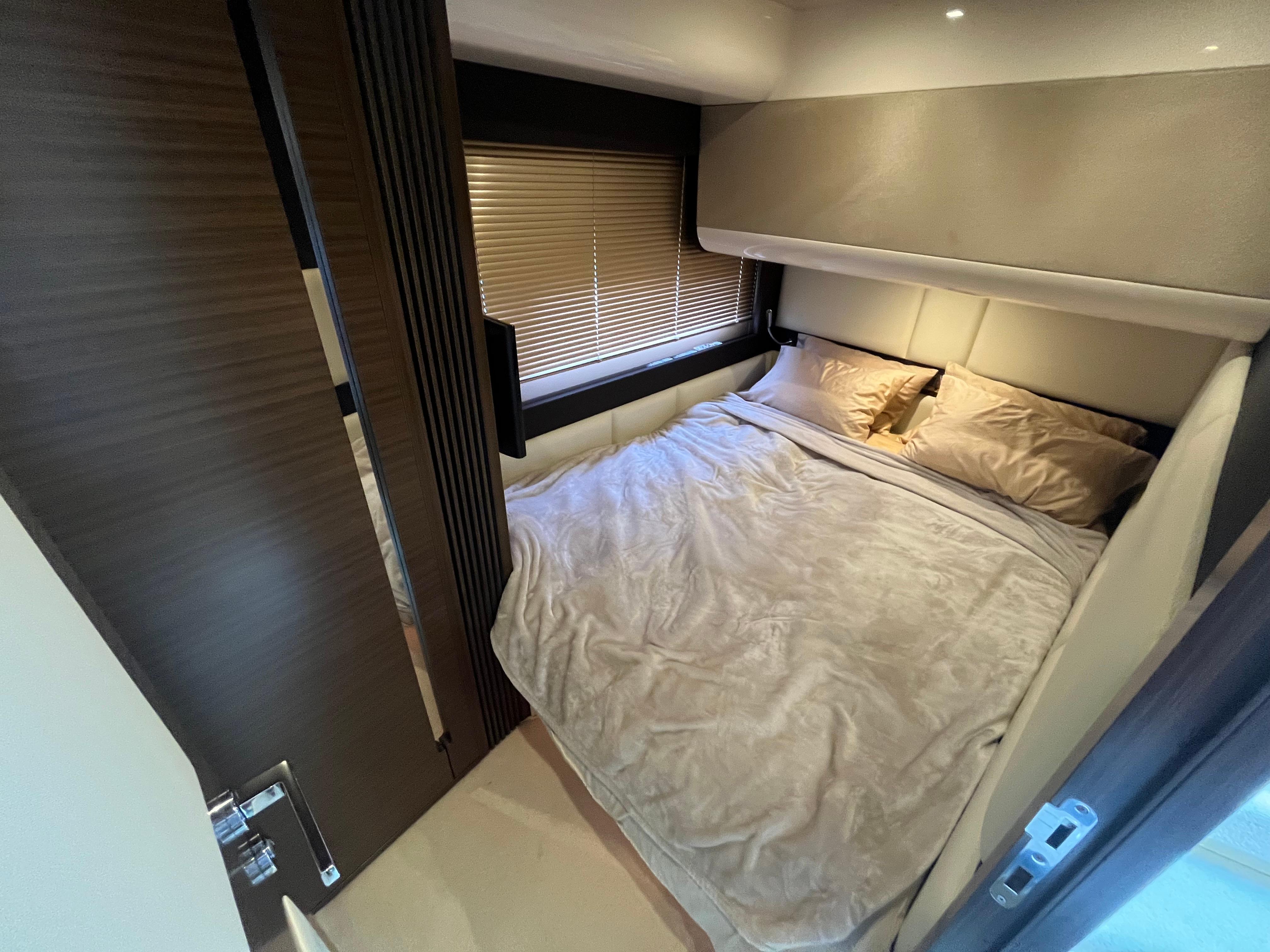 Luxurious bedroom interior of 2014 Azimut 55S yacht with cozy bedding and modern design.
