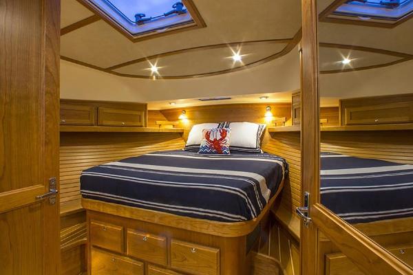 Interior of a luxurious cabin with wooden walls, a large bed, and skylights.