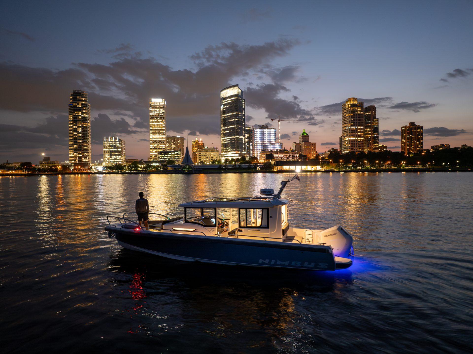 Nimbus Commuter 9 boat on water at dusk, city skyline in background, 2025 model.