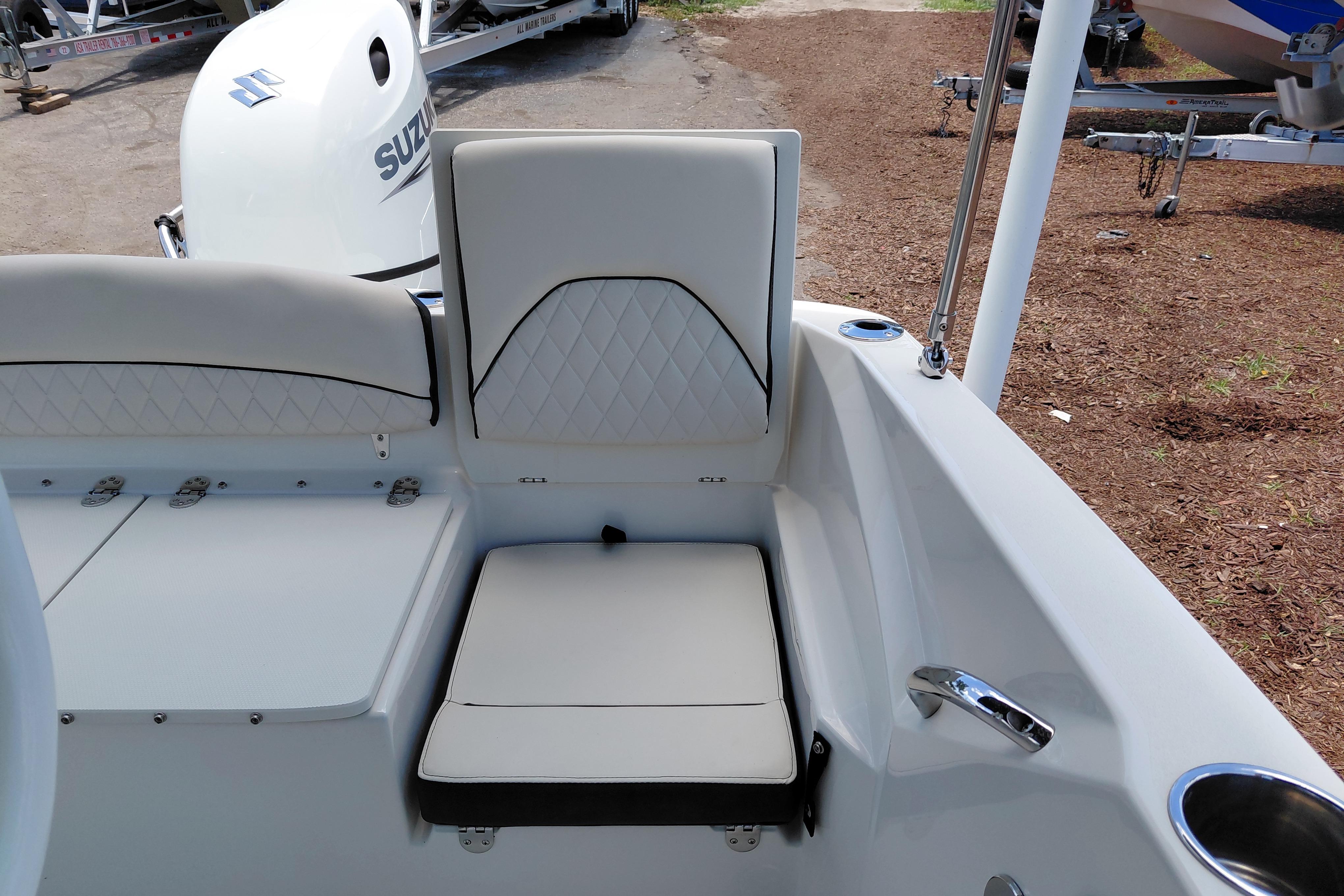 2023 Stingray 206 CC boat interior with white seating and Suzuki outboard motor.