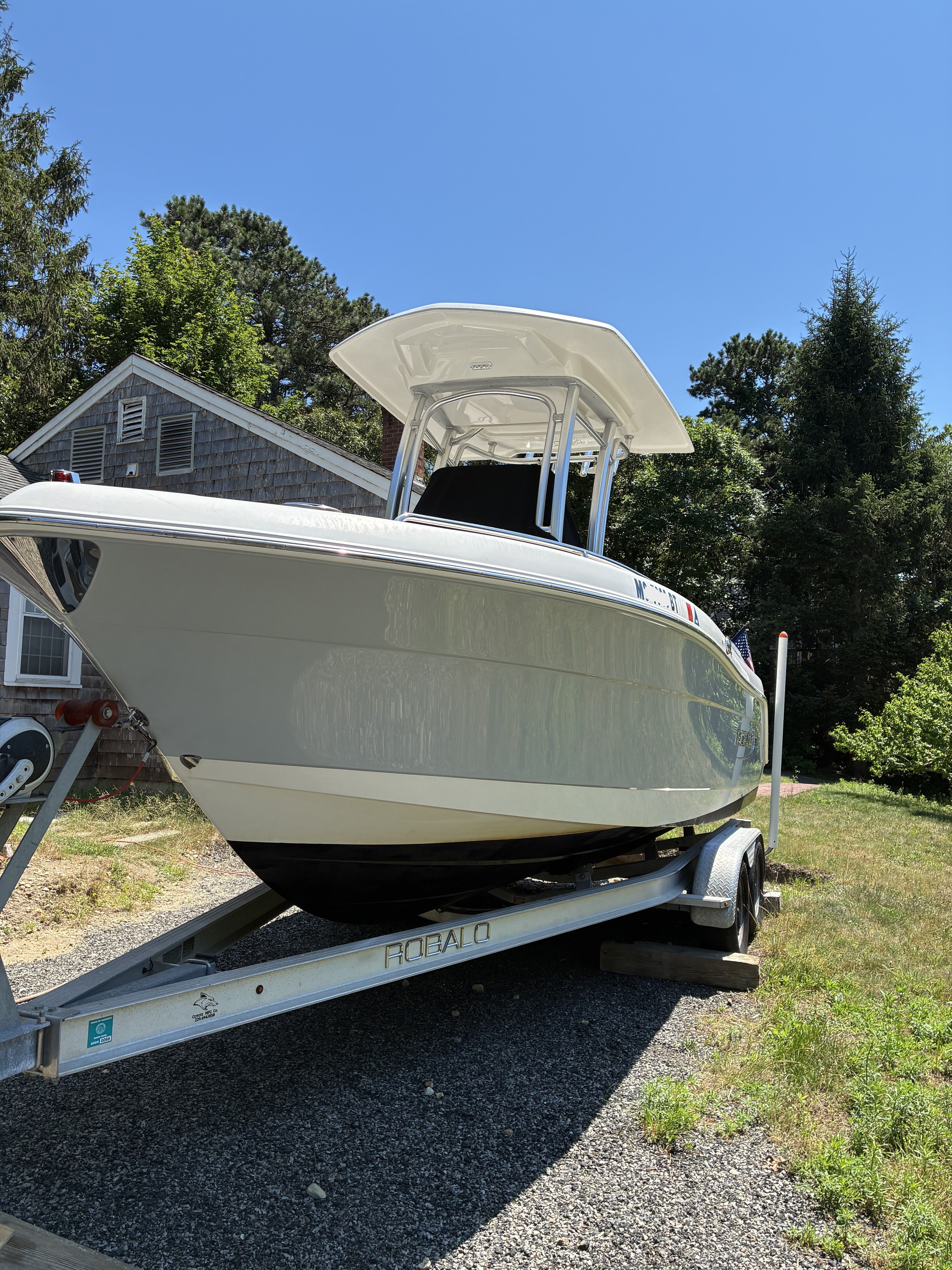 A 2019 Robalo R222 Center Console boat on a trailer in a yard.