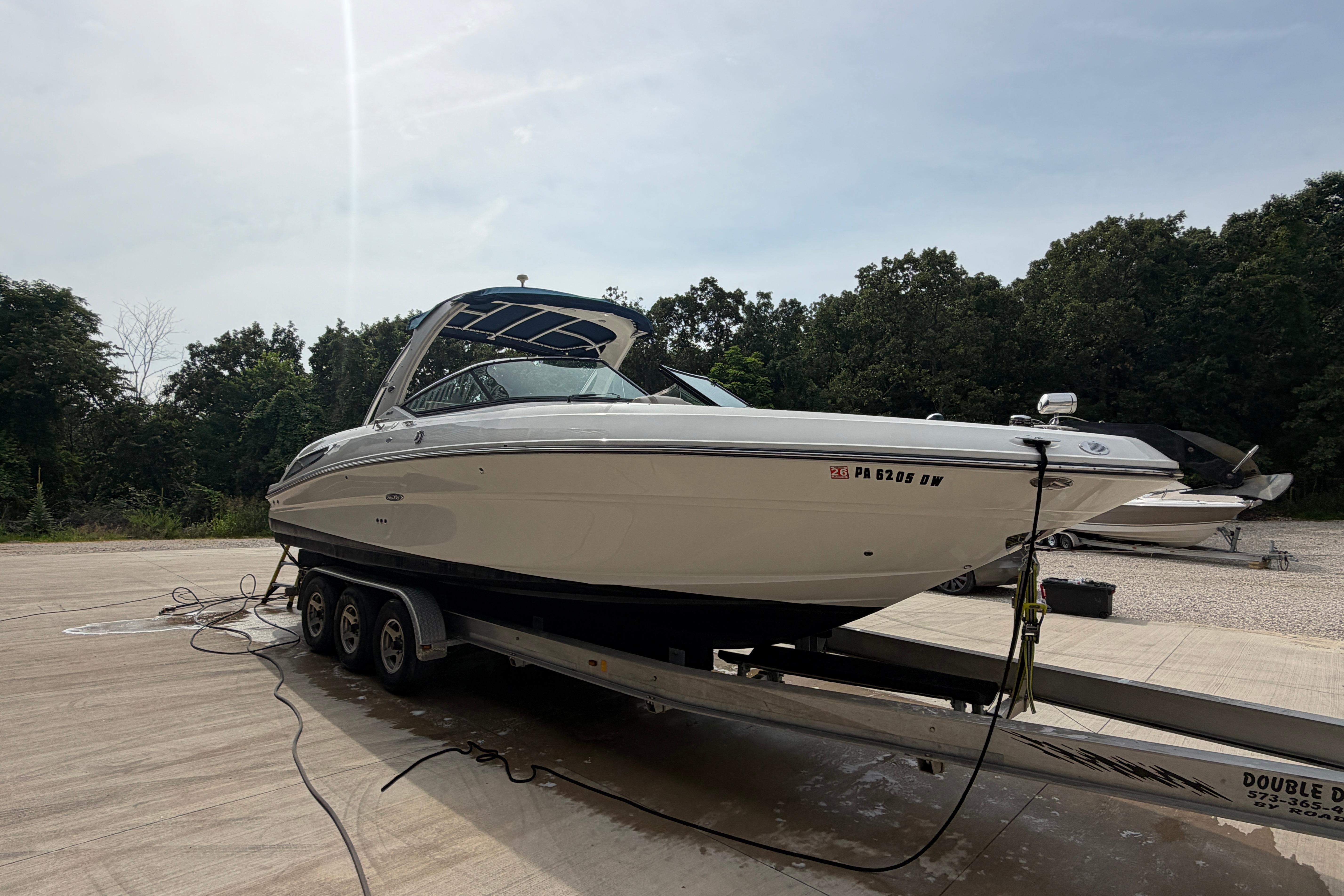 2013 Sea Ray 300 SLX boat on trailer, parked outdoors with trees in background.