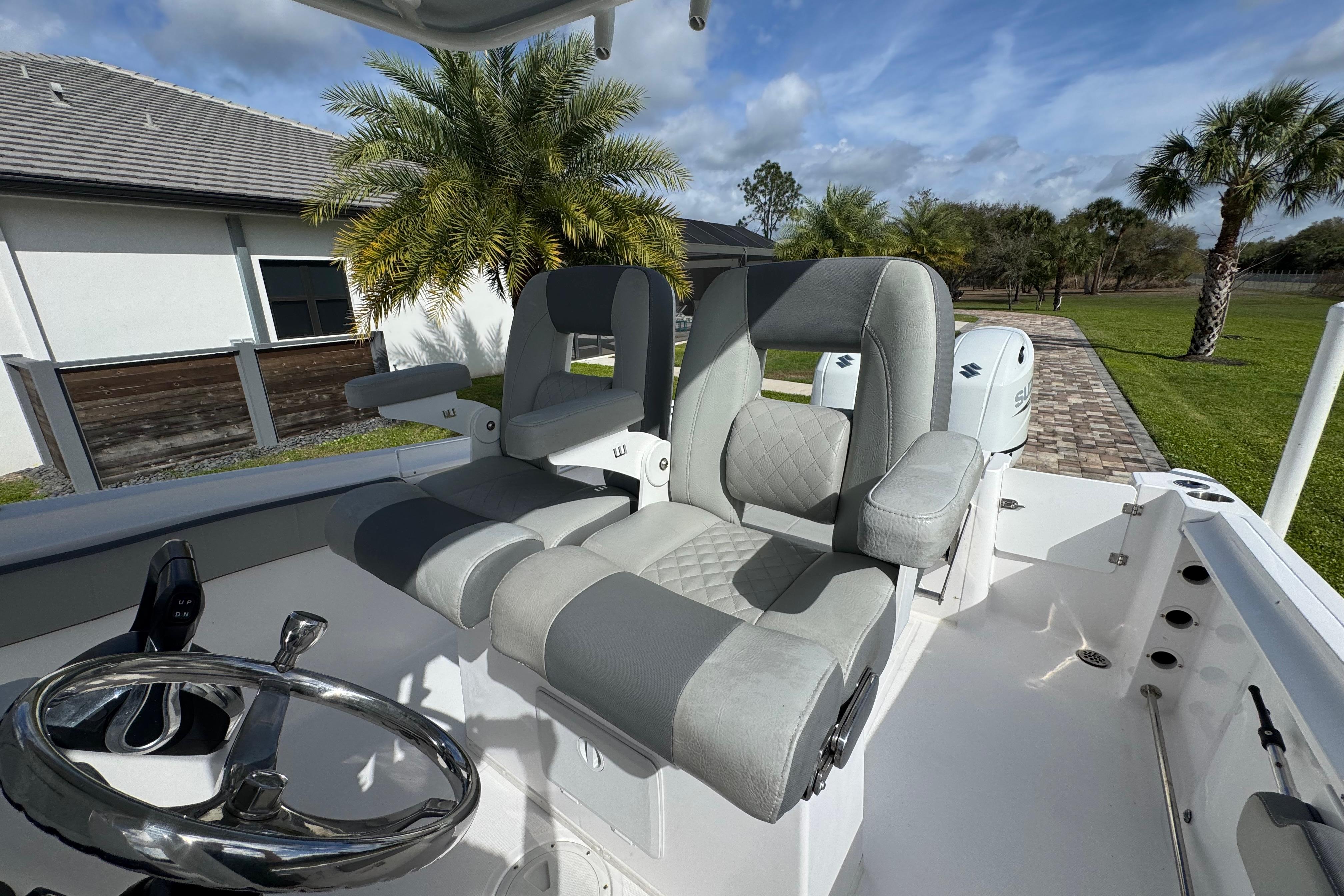 2022 Aquasport 2500 Center Console boat with dual seats and steering wheel, outdoor setting.