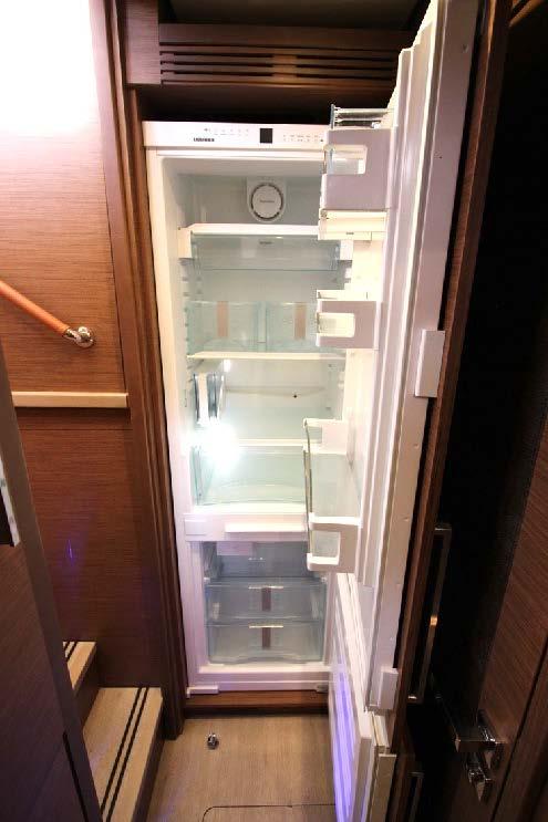 Open refrigerator inside Lagoon 620 yacht, showcasing spacious interior and modern design.