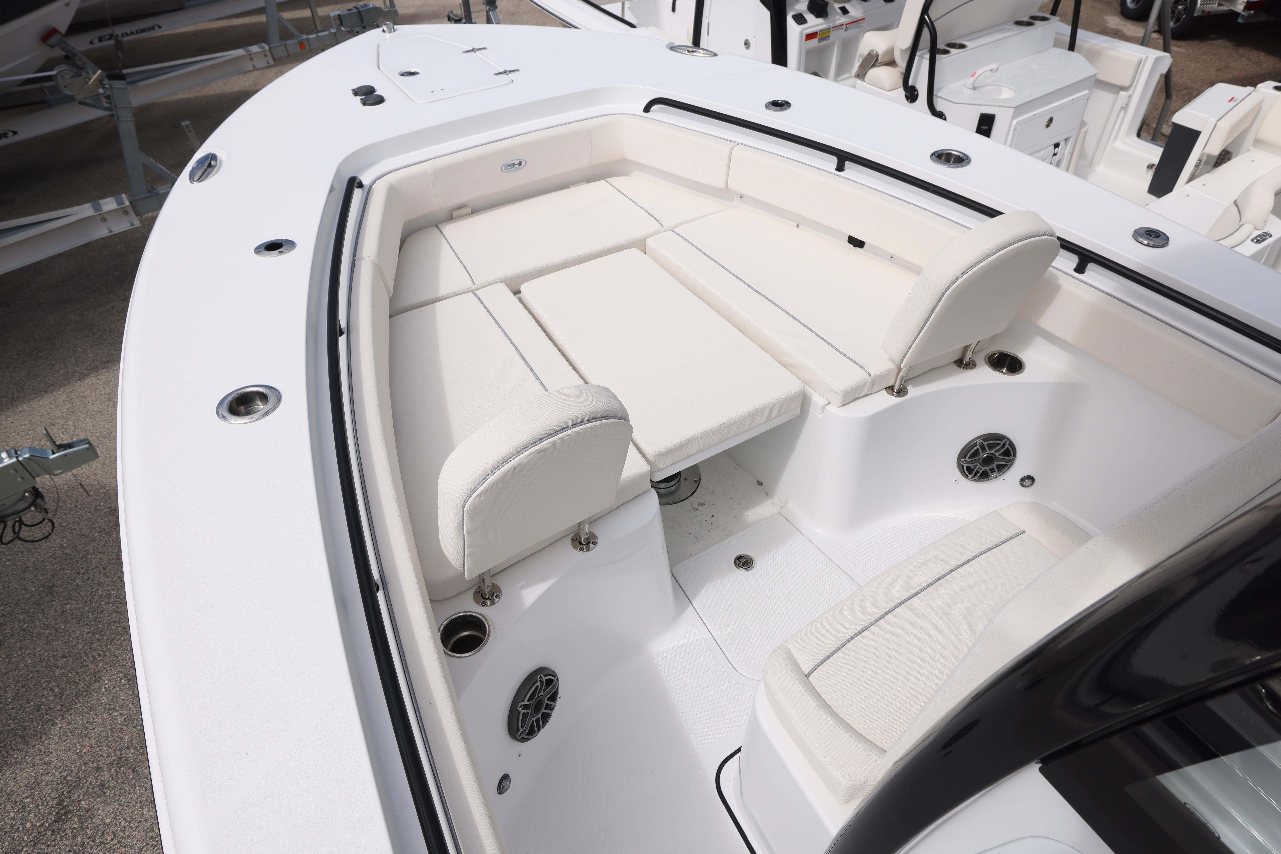 2026 Sea Hunt Gamefish 25 boat interior with white cushioned seating and cup holders.