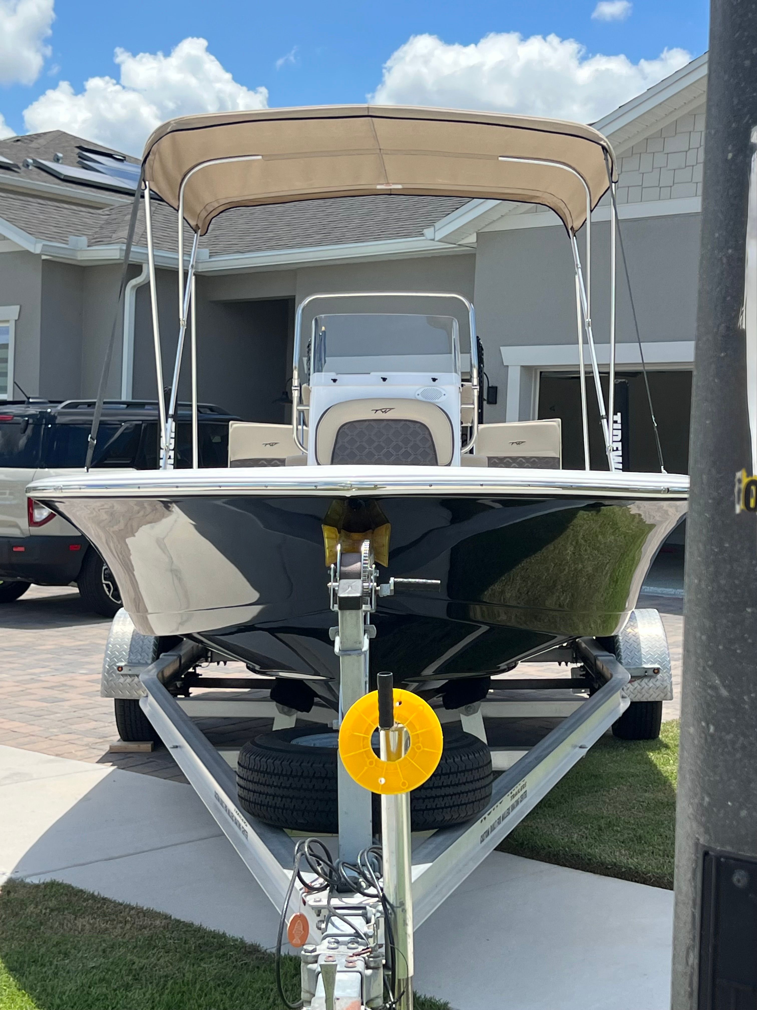 A 2021 Tidewater 1910 Bay Max boat on a trailer in front of a house.