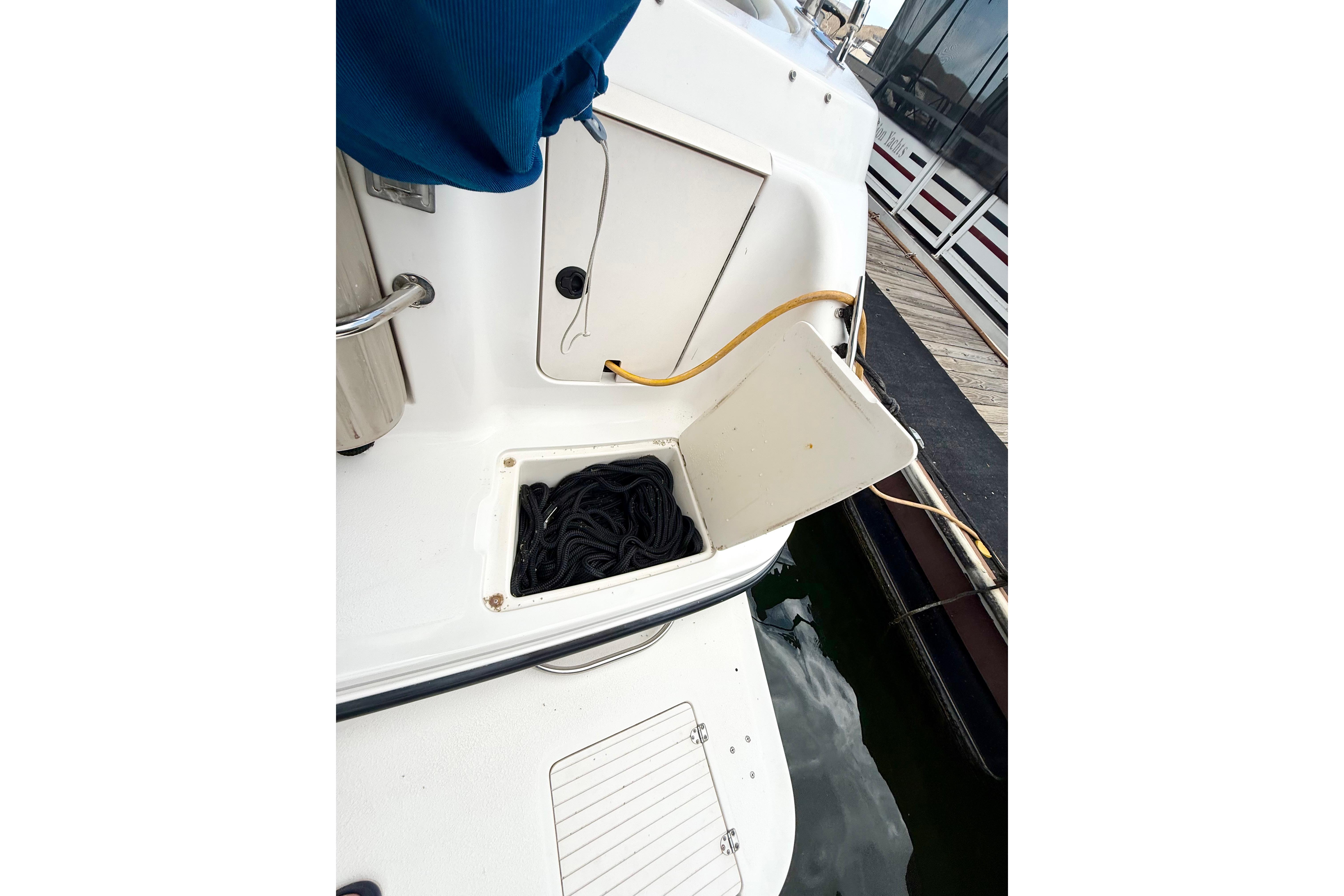 1999 Chaparral Signature 300 boat with open storage compartment and dockside view.