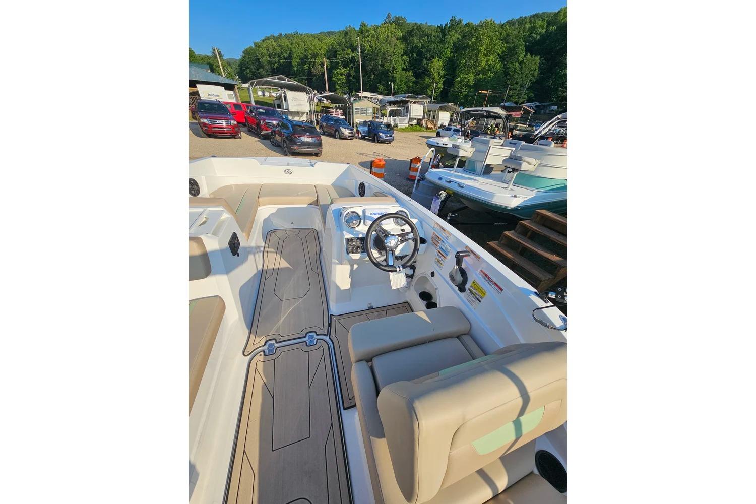 2025 Hurricane SunDeck Sport 205 OB boat interior with steering wheel and seating, parked outdoors.