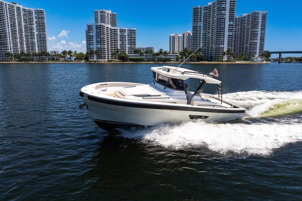 2021 Bluegame BG 42 yacht cruising on water with city skyline backdrop.