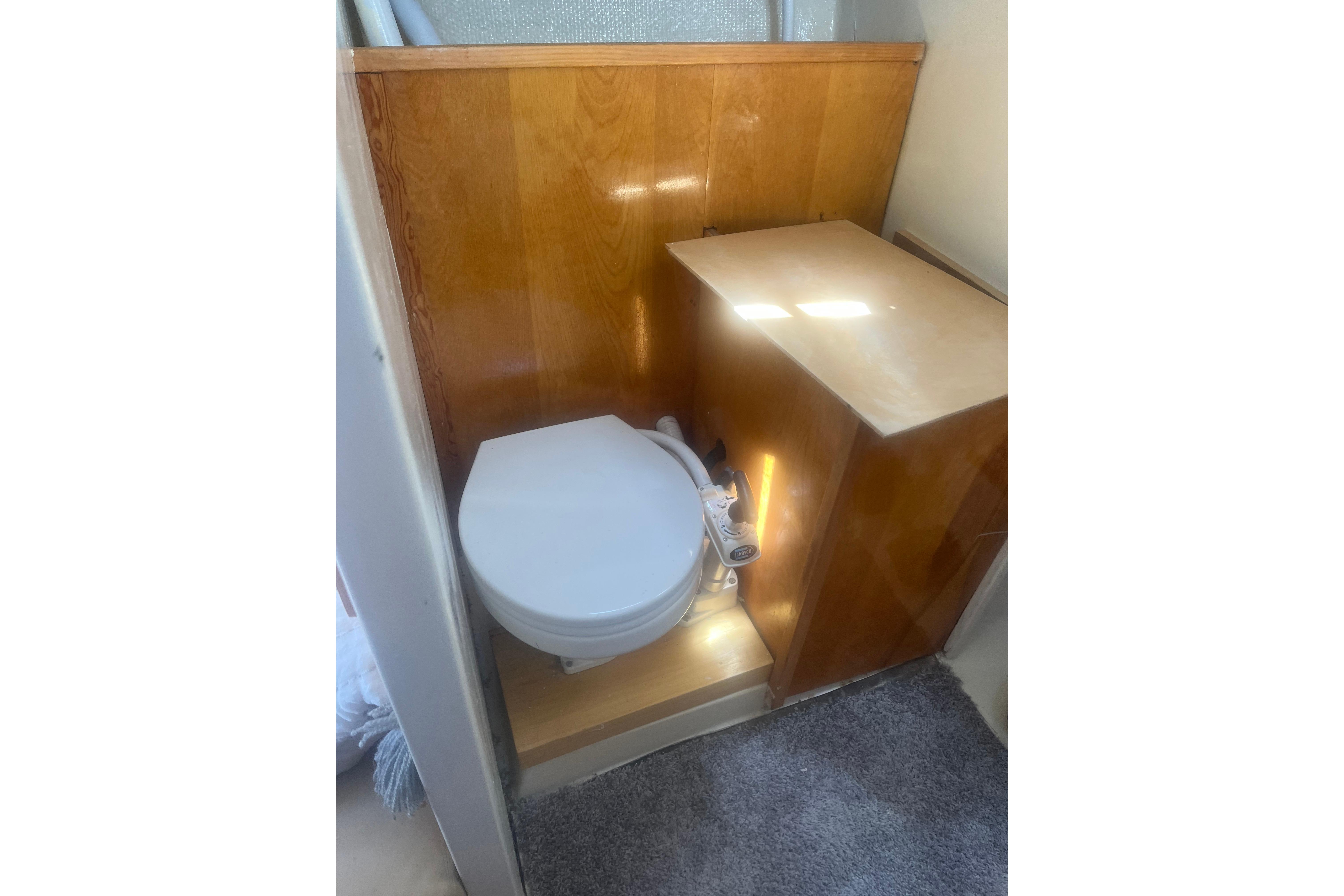 Wood-paneled boat bathroom with toilet, C&C 30, 1972 model.
