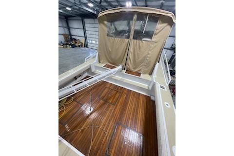 1964 Striker Model 120 boat with wooden deck and beige canopy in a storage facility.