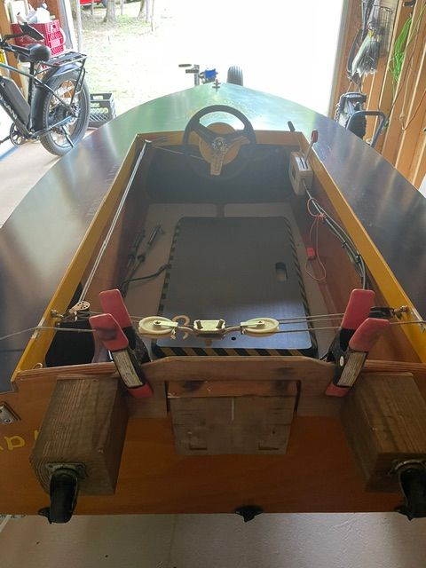 A 2013 Custom Racer in a garage, featuring a minimalist cockpit and wooden details.