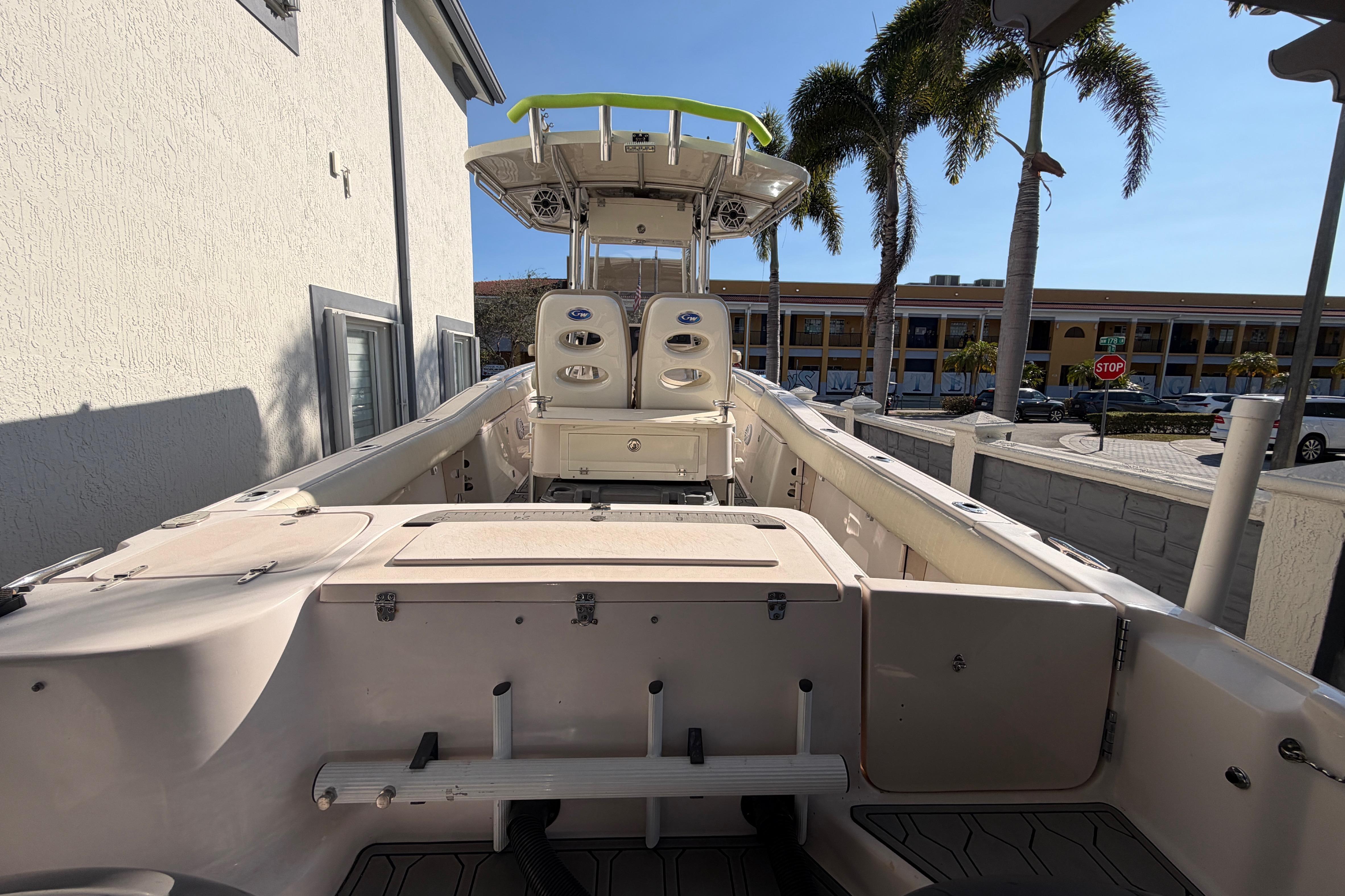 2004 Grady White 273 boat with seating, docked near palm trees and buildings.