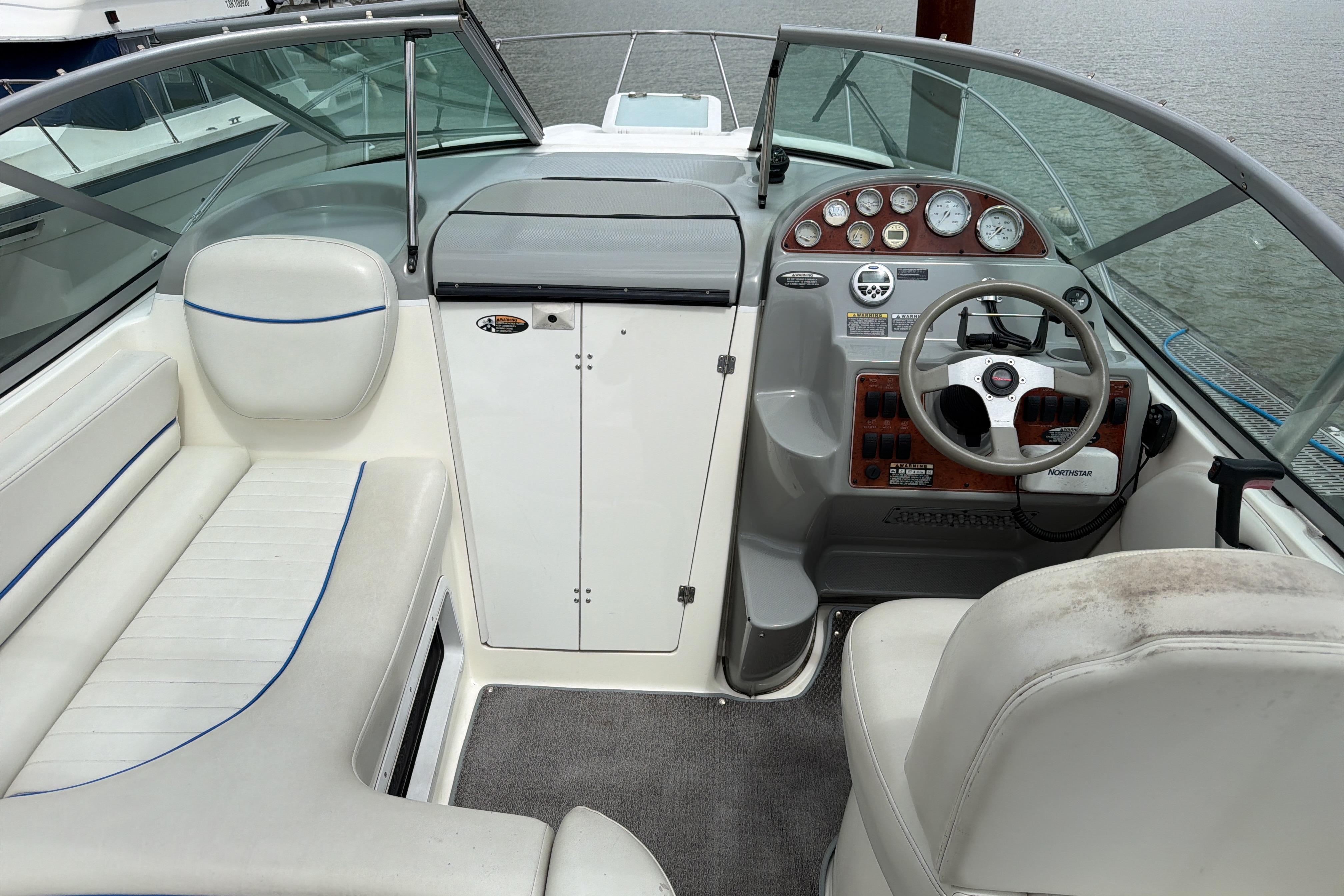 Interior view of a 2007 Bayliner 245 boat cockpit with steering wheel and seating.