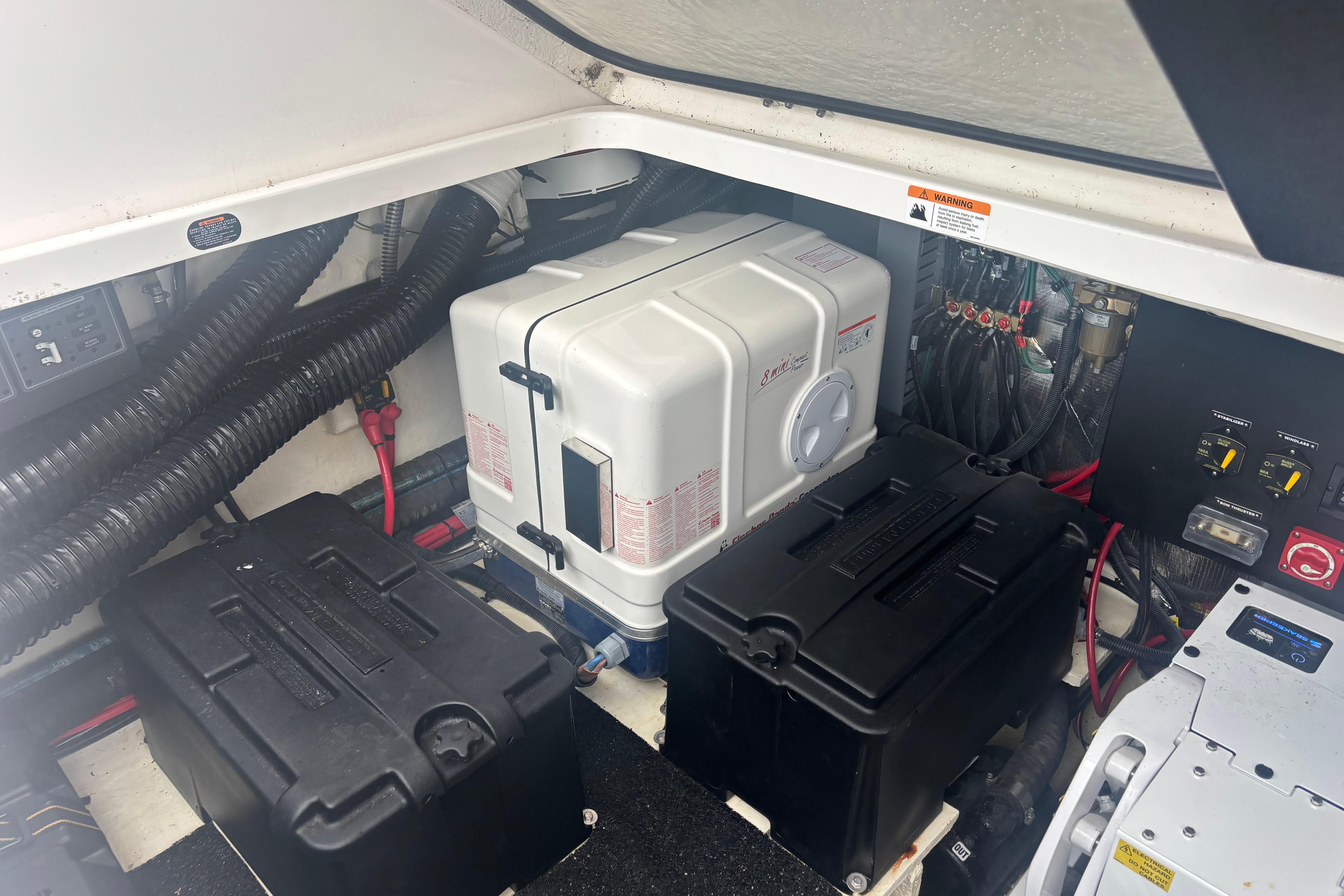 Engine compartment of 2024 Regal 36 XO boat, featuring batteries and wiring.