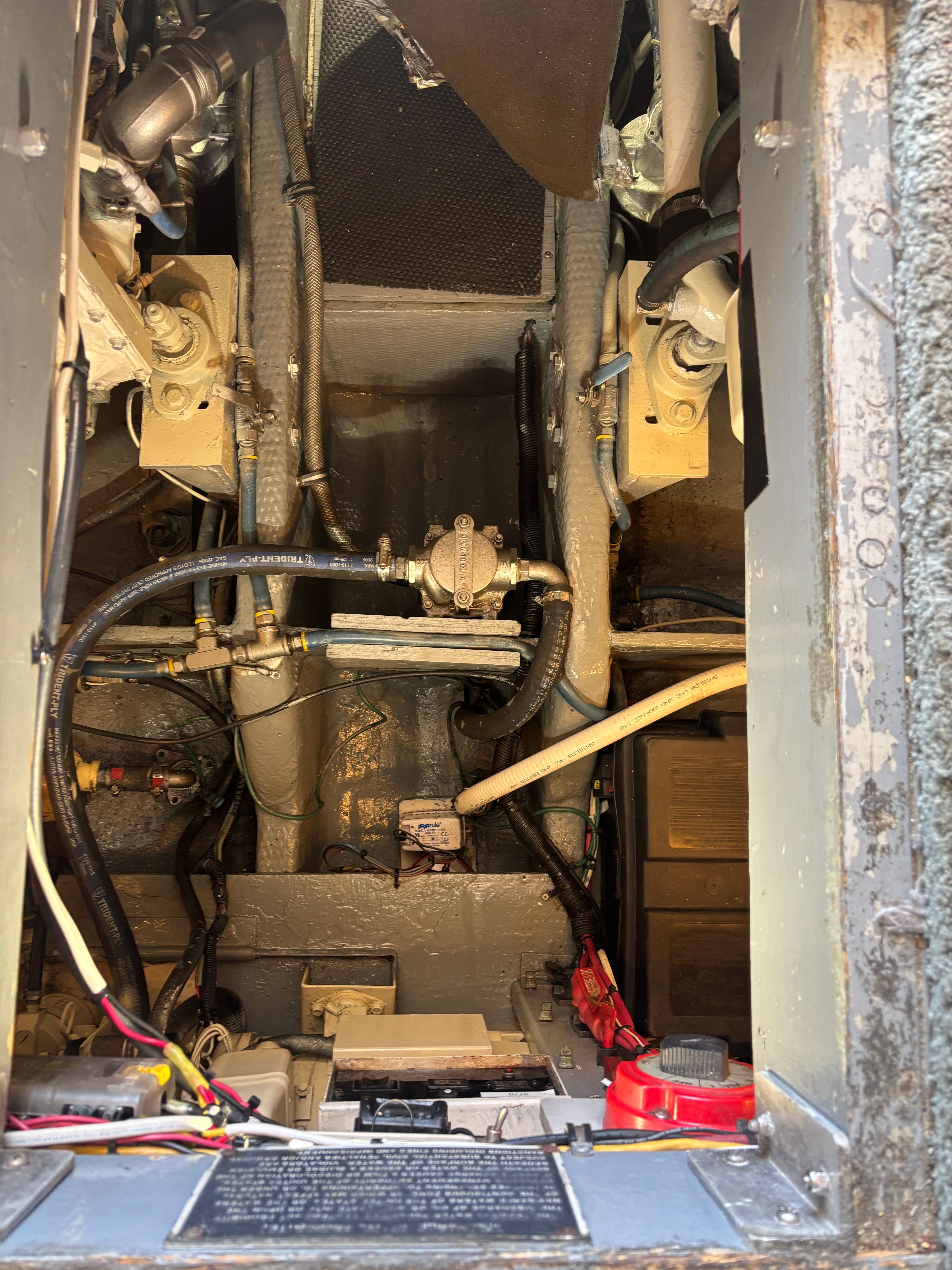 View inside the engine room of a 1989 Luhrs 350 Tournament with hoses and cables.