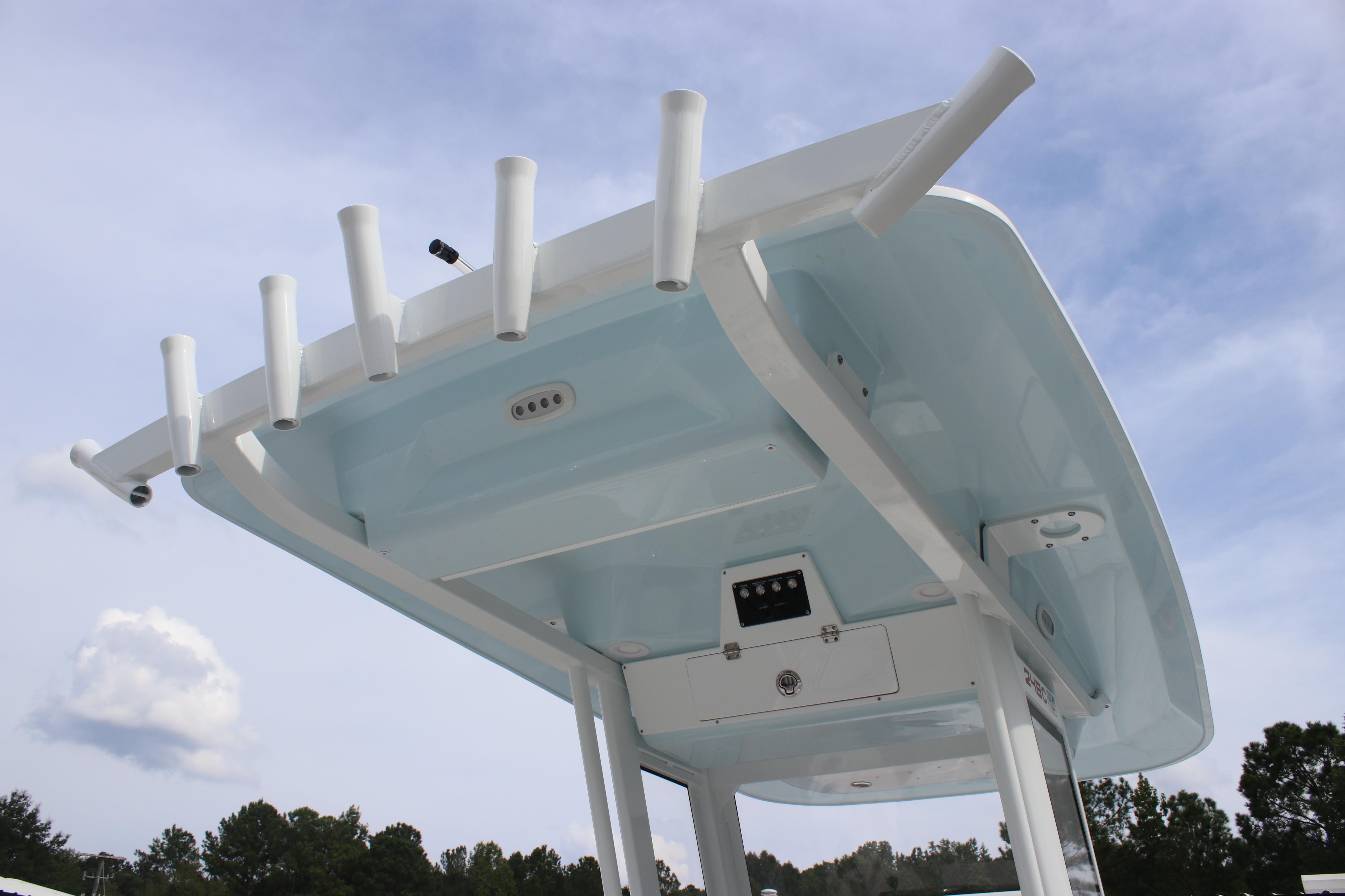 2026 Sea Fox 248 Commander boat top with rod holders against a blue sky.