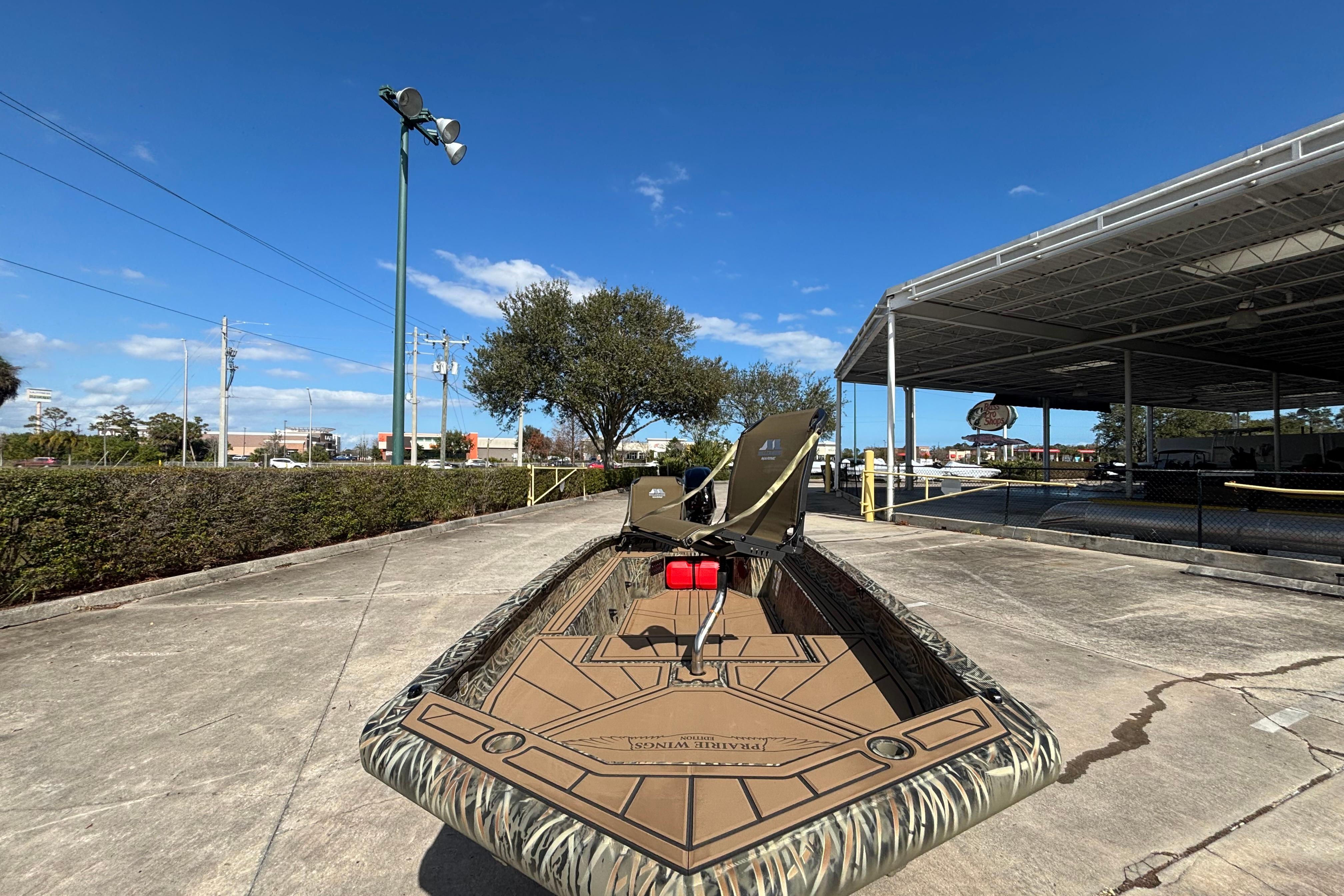 2026 Tracker Grizzly 1650 T Prairie Wings Edition boat on display under clear blue sky.