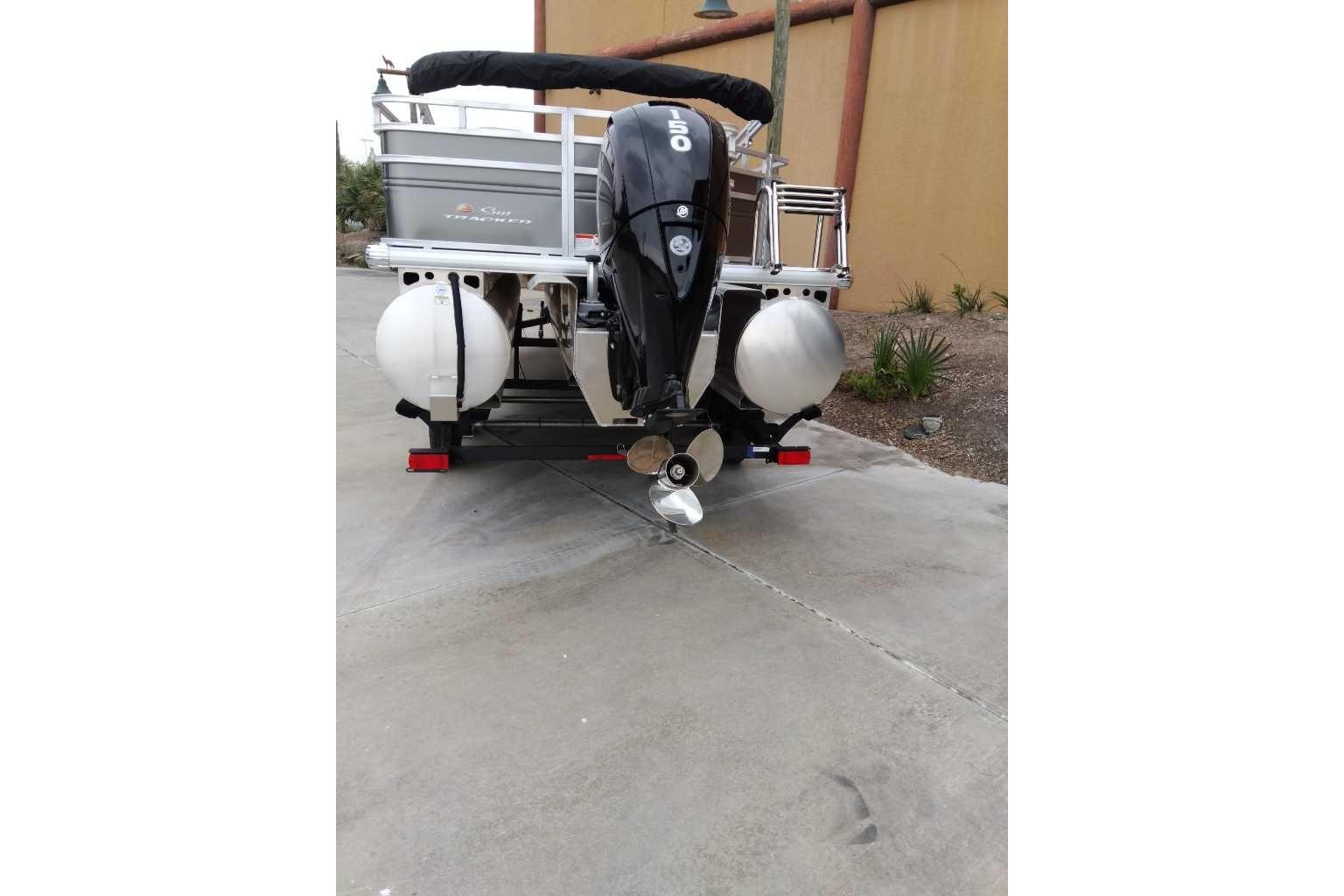 2025 Sun Tracker Fishin' Barge 22 XP3 pontoon boat with outboard motor, rear view.