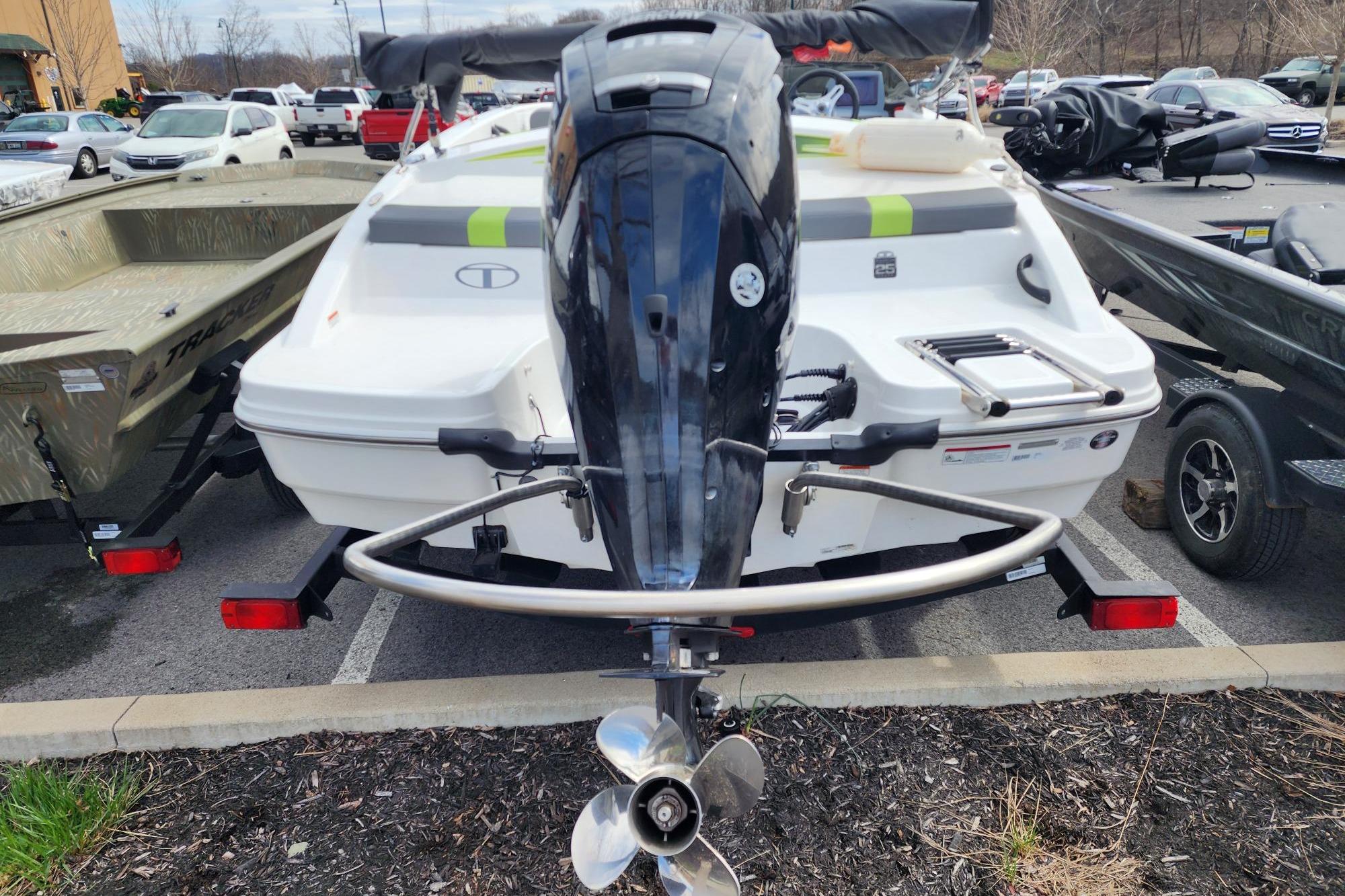 2023 Tahoe T18 boat with outboard motor in a parking lot.