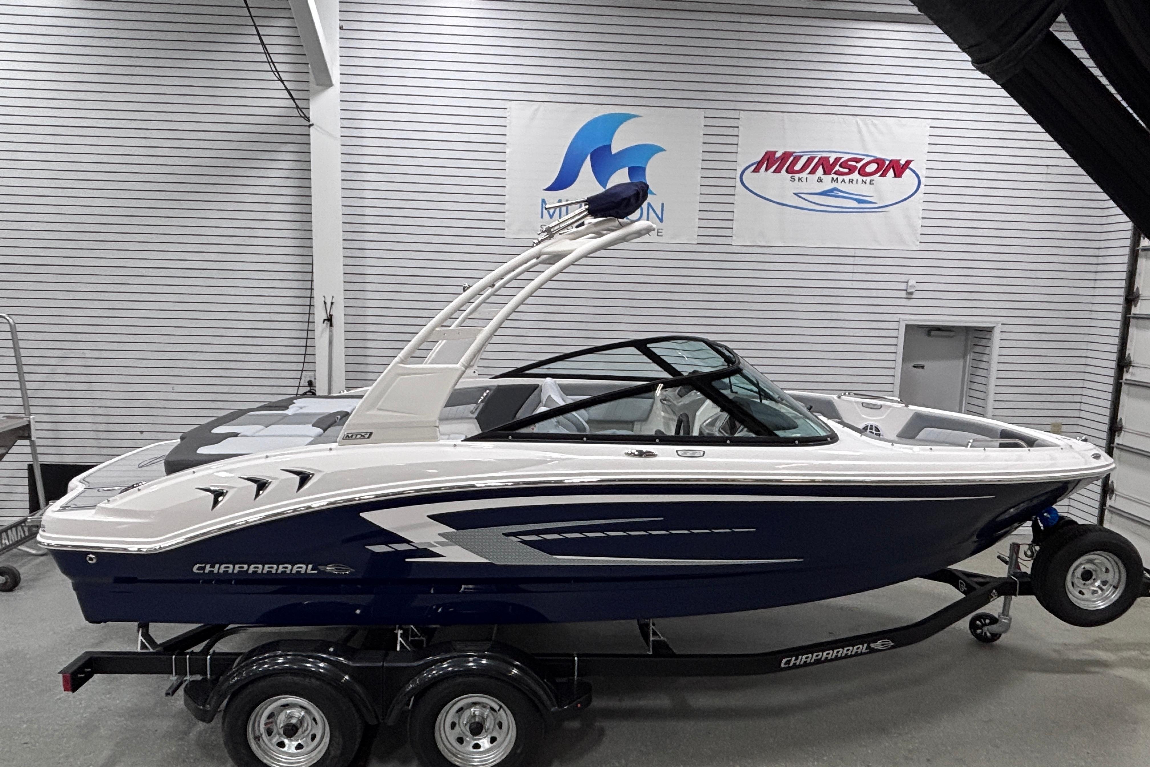 2026 Chaparral 21 SSi boat in showroom, sleek design, blue and white color scheme.