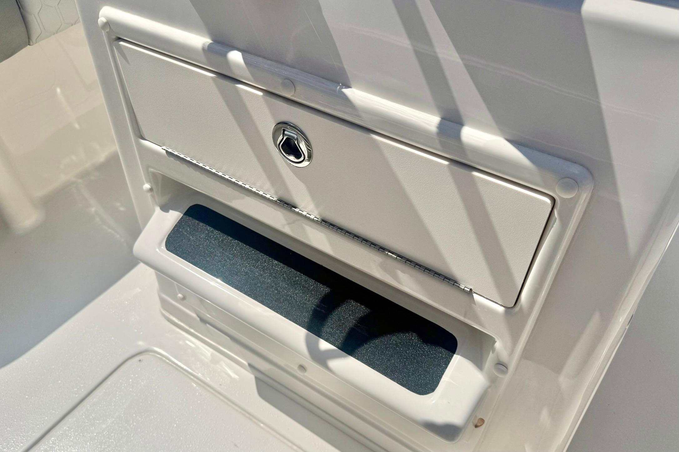 2026 Carolina Skiff 21 Ultra Elite storage compartment with secure latch and sleek design.