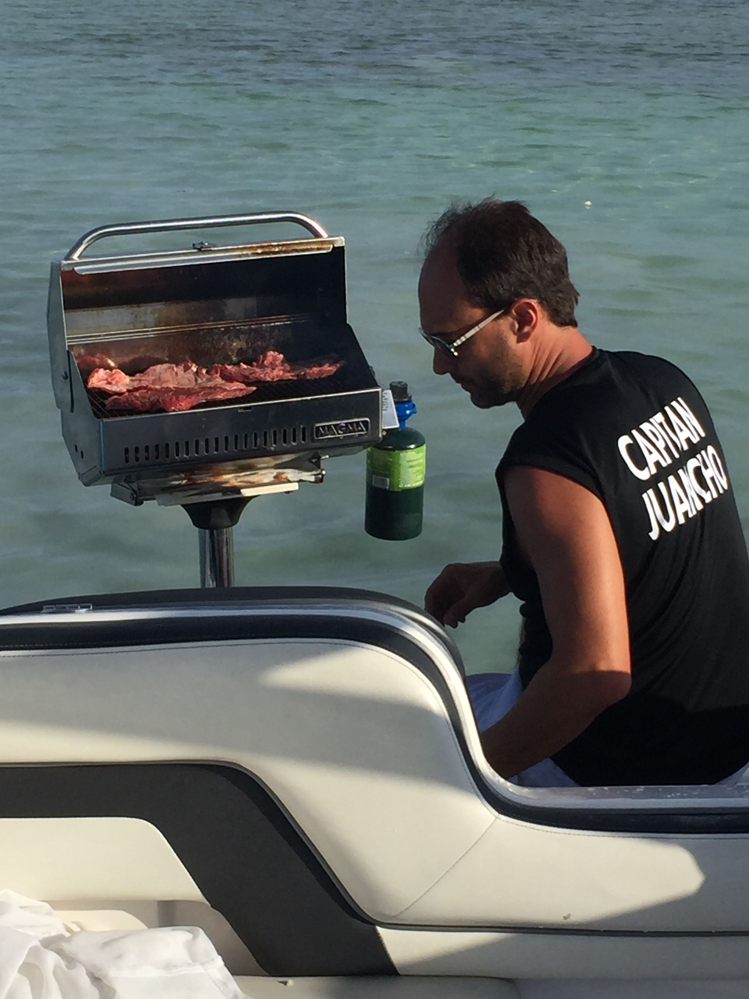 Man grilling meat on 2016 Yamaha AR240 boat.