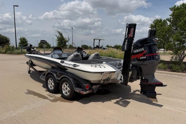 2008 Ranger Z21 Comanche boat with Yamaha engine on a trailer, parked outdoors.