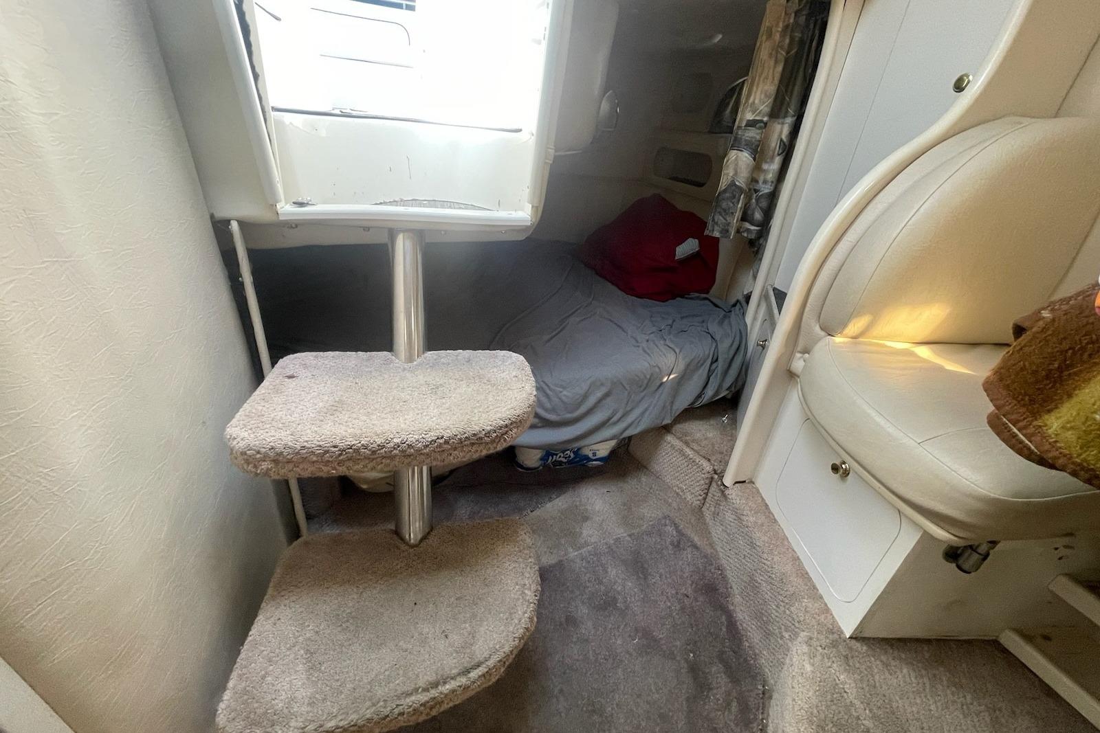 Interior cabin of 2000 Rinker Fiesta Vee 310 with cozy sleeping area and carpeted steps.