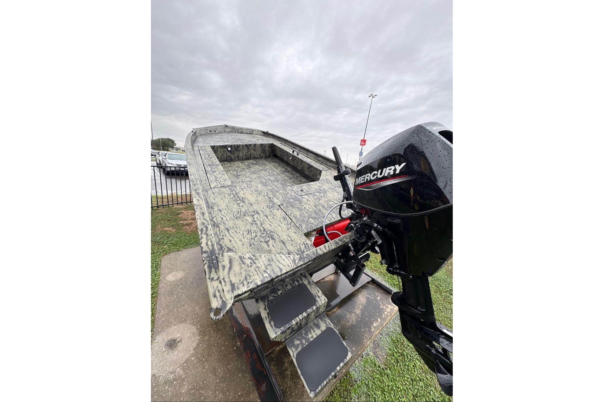 2026 Tracker Grizzly 1654 T Sportsman boat with Mercury outboard motor on display.