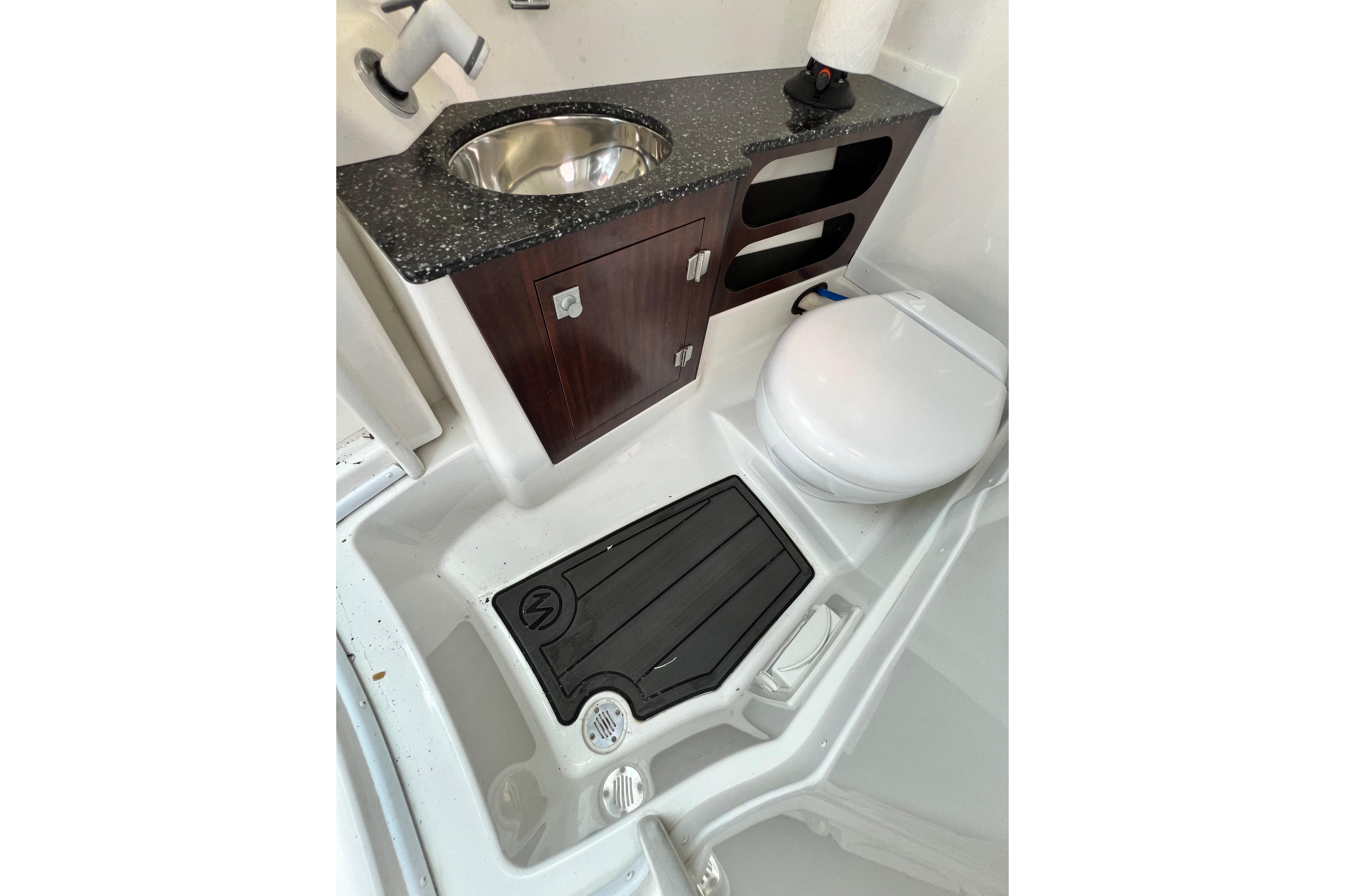 2015 Monterey 268SS Super Sport boat bathroom with sink, toilet, and storage cabinet.