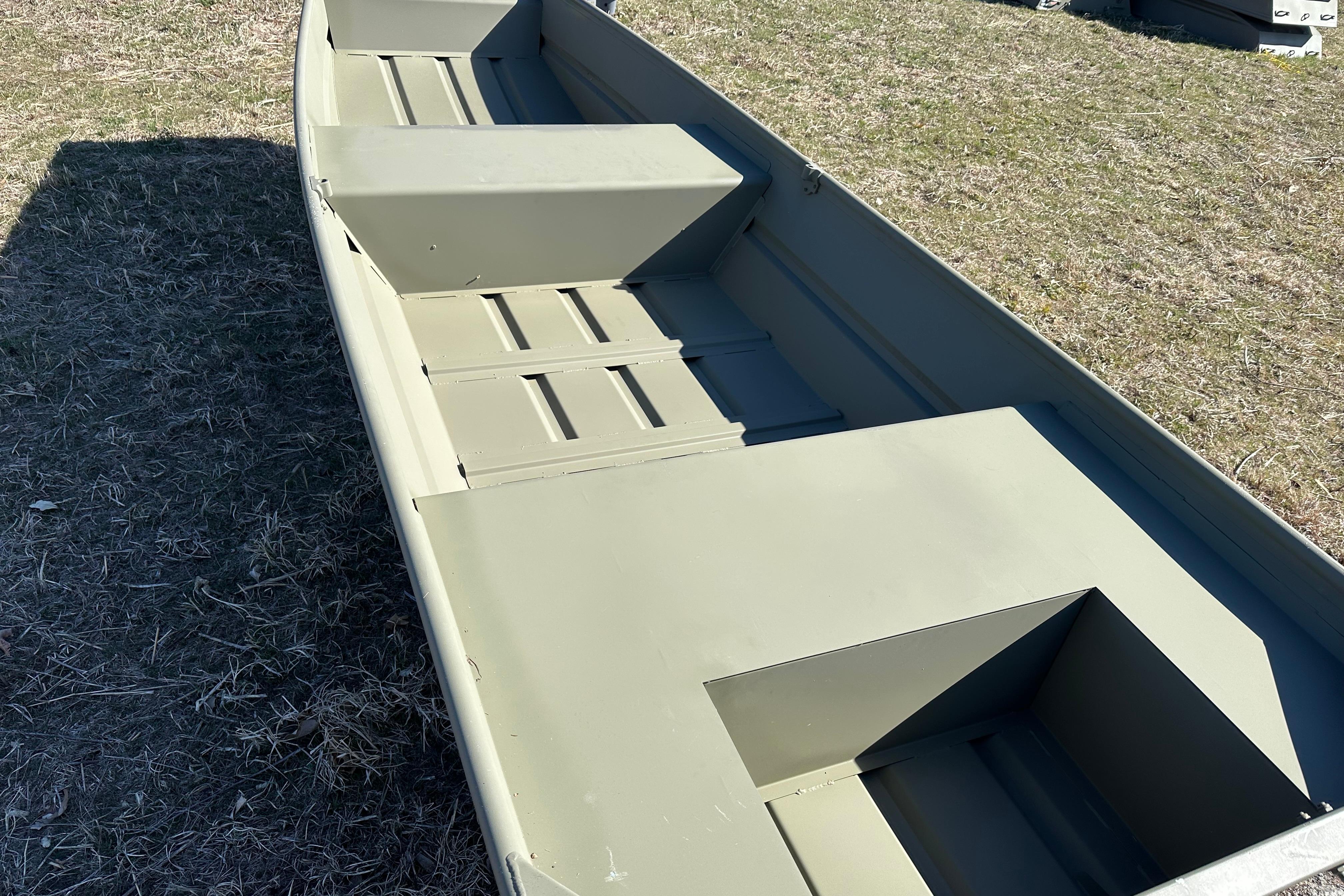 2026 Tracker Grizzly 14 Jon boat on grass, showcasing interior seating and storage.