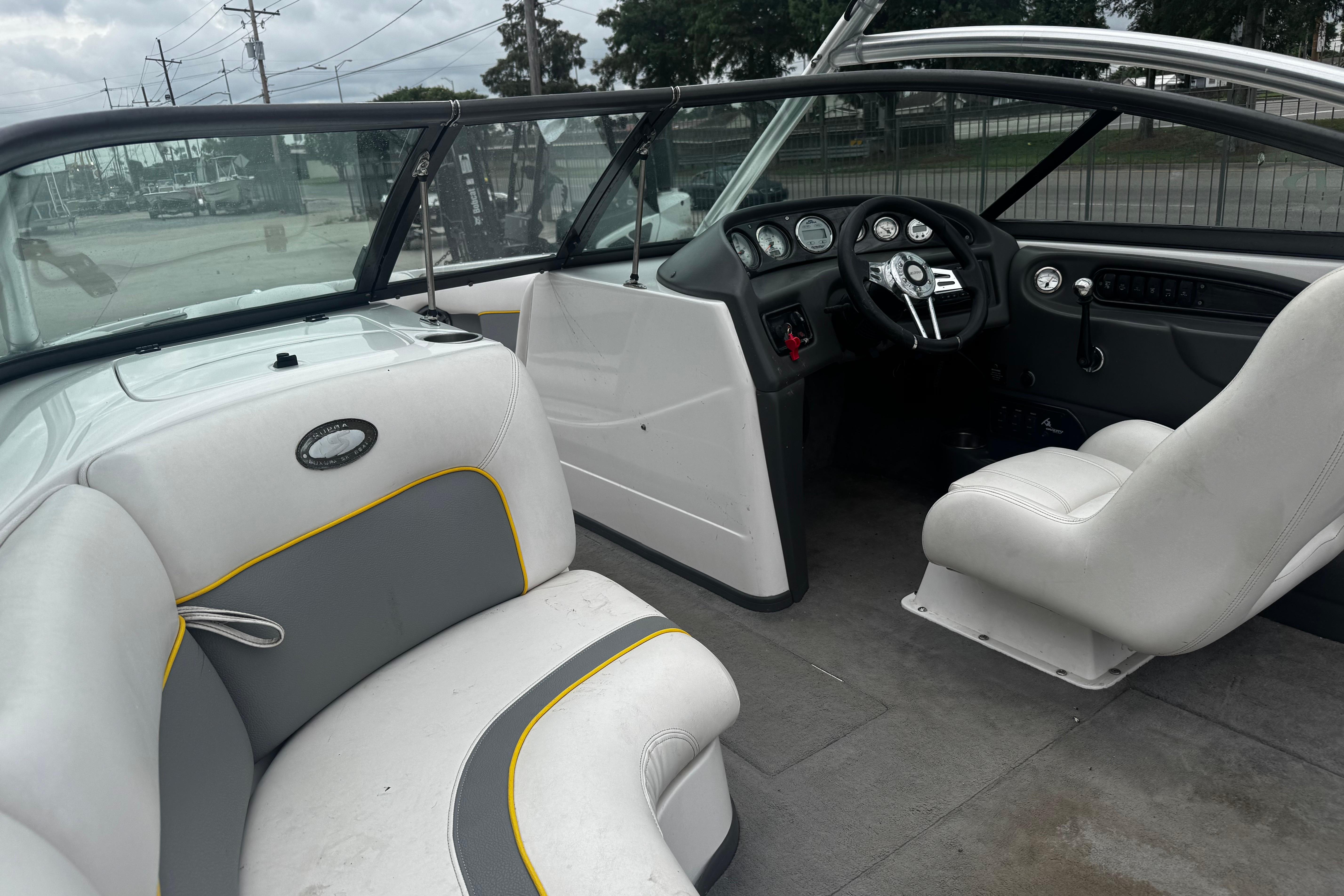 2006 Supra Launch 22 SSV boat interior with white and gray seating, dashboard, and steering wheel.