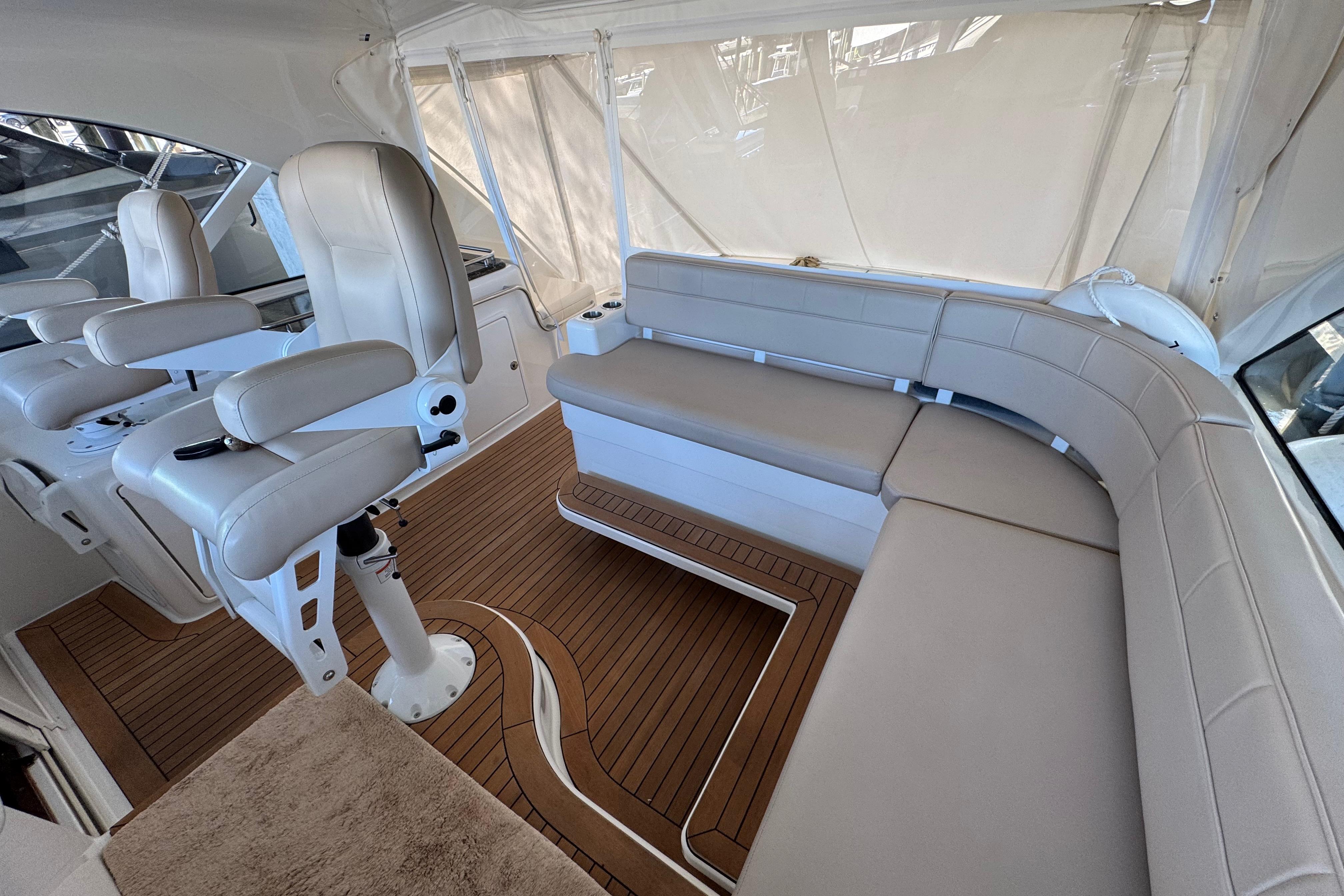 Luxurious interior of 2013 Cabo 44 Hardtop Express yacht with plush seating and wood flooring.