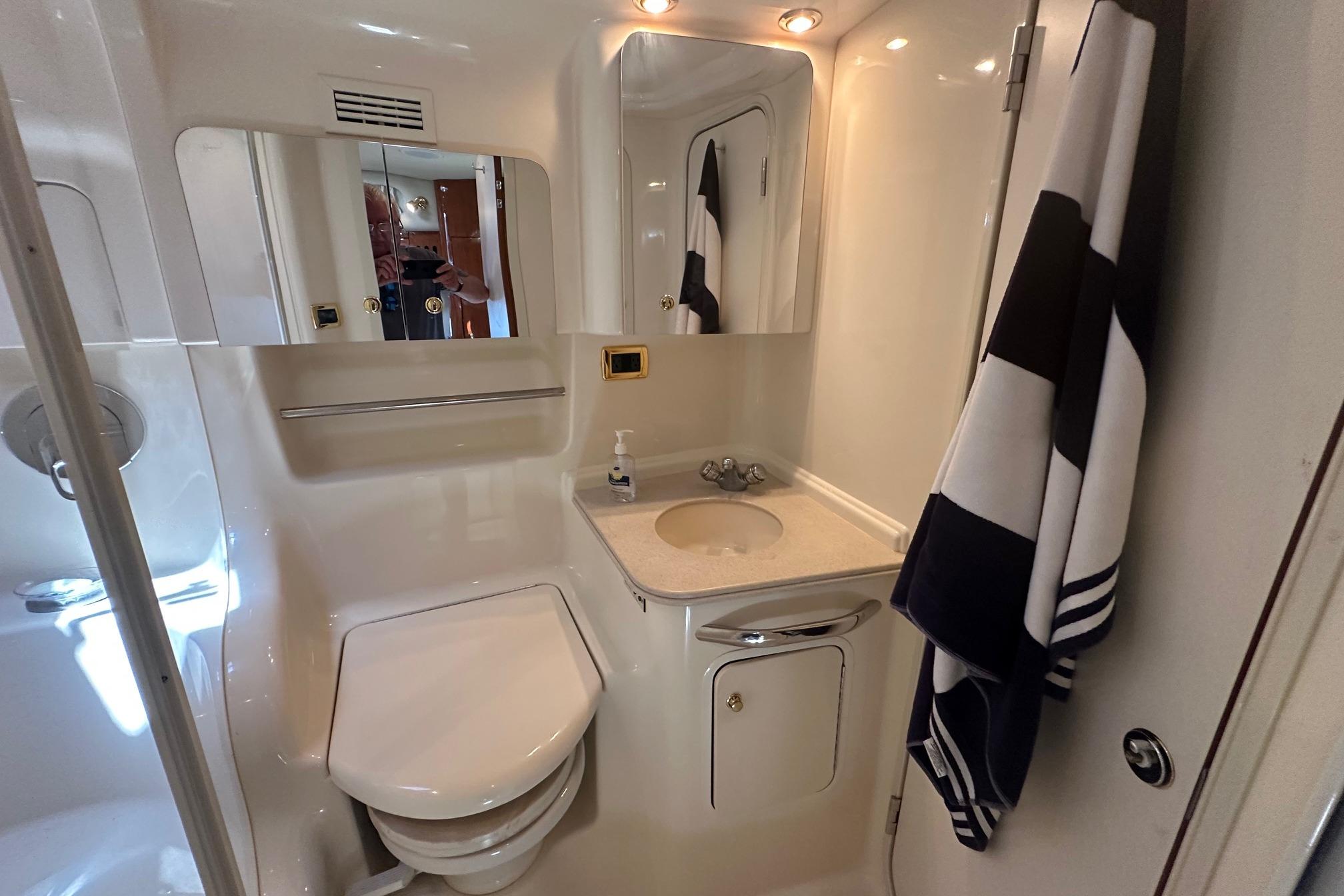 Luxurious bathroom in 2001 Sea Ray 410 Sundancer yacht, featuring sink, mirror, and towel.