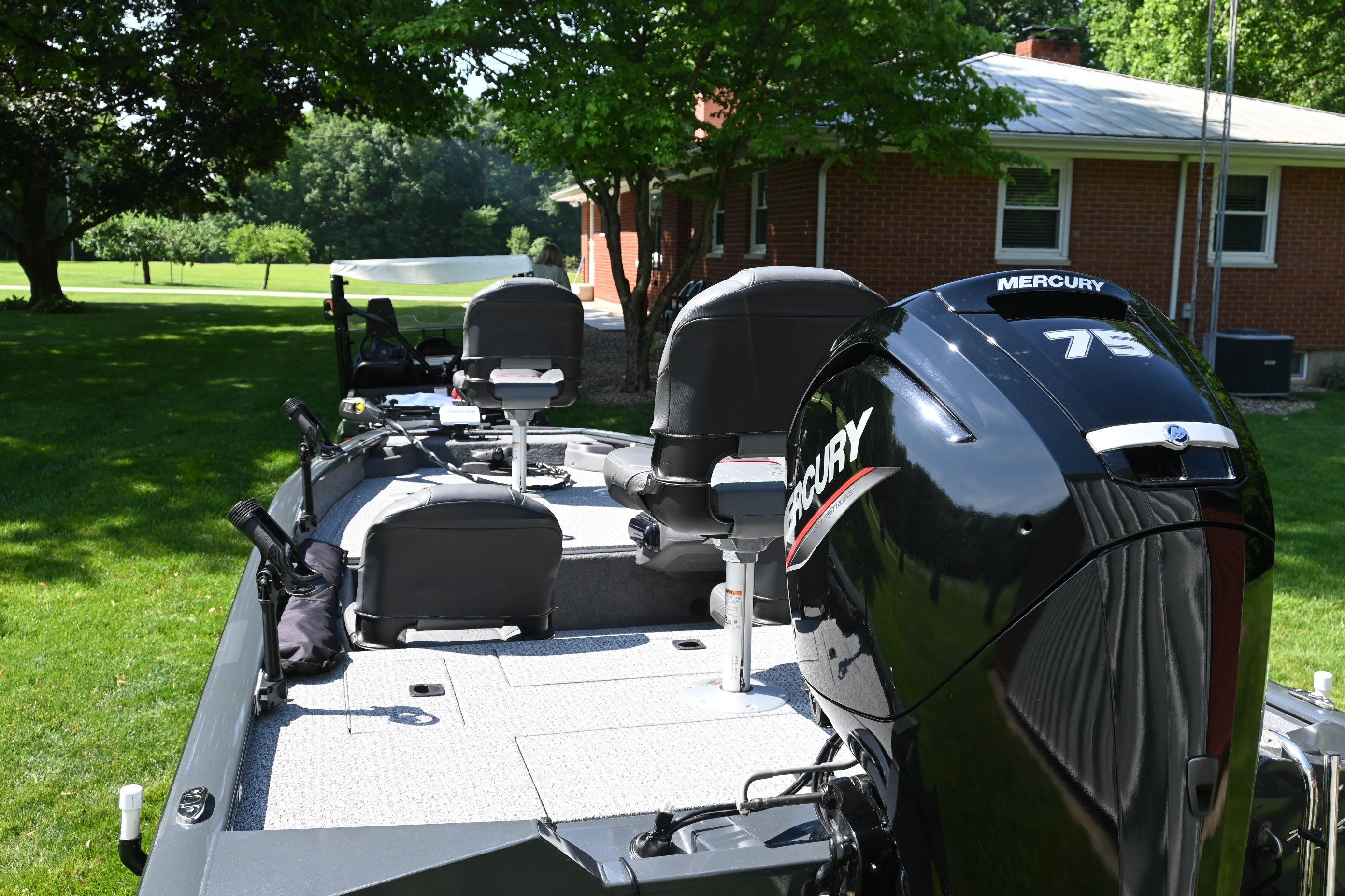 2022 Tracker Pro 175 TF with Mercury 75 HP engine, parked on grass in front of a brick house.