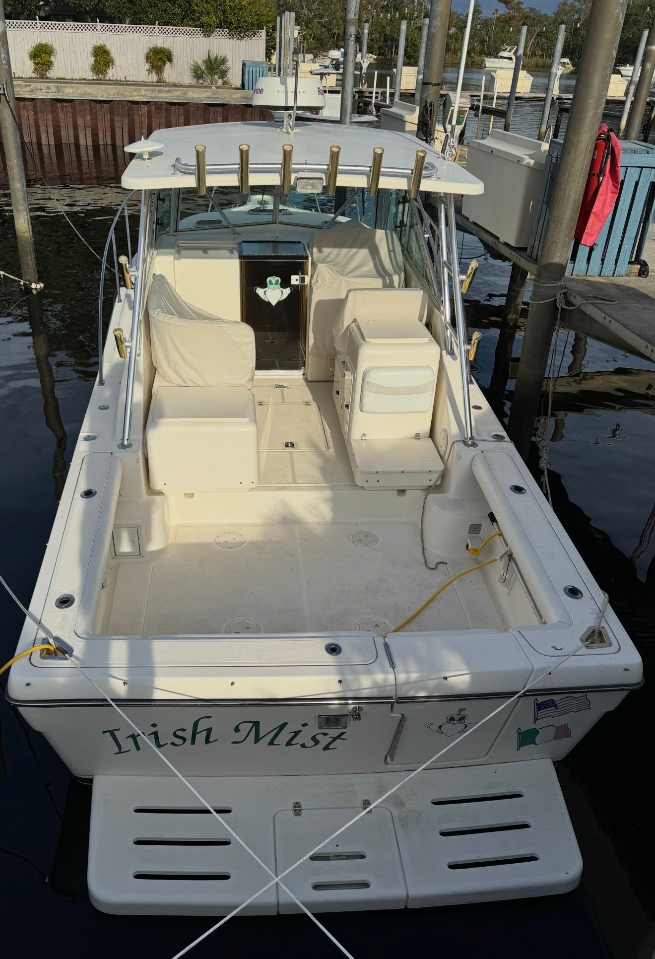 A 2002 Pursuit 3000 Express boat named "Irish Mist" is docked. It features a spacious cockpit with seating and rod holders.