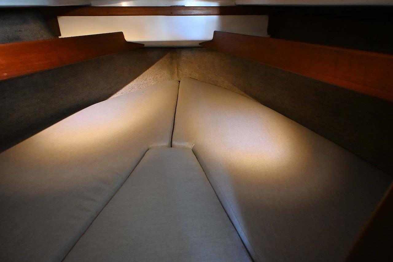 Interior cabin view of 1977 Mercator Offshore boat with cushioned sleeping area.