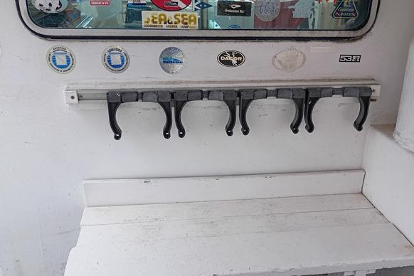 1980 Thompson Passenger and Dive Trawler interior with hooks and various stickers on the wall.