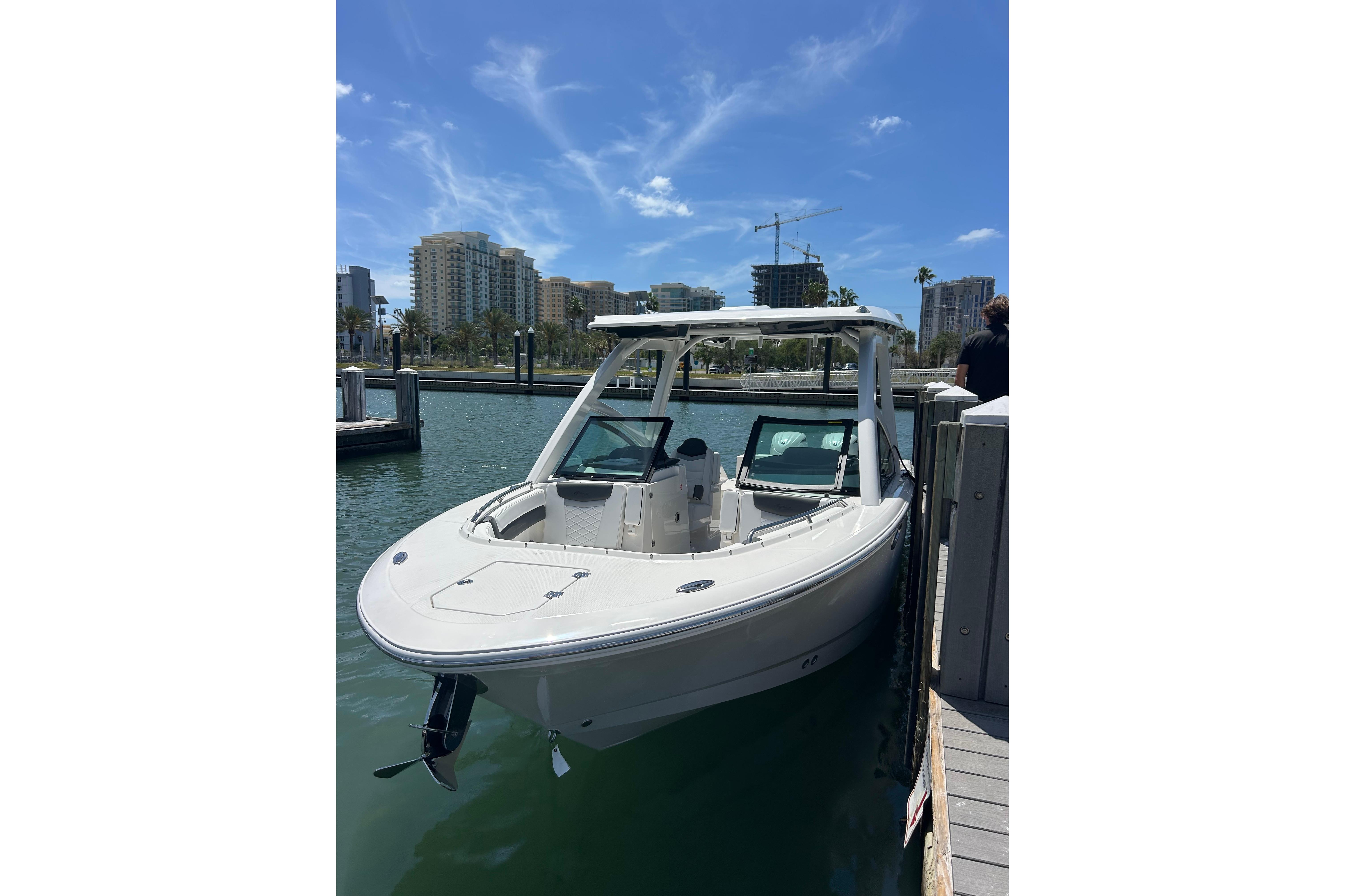 2026 Robalo R257 Dual Console boat docked in a marina under a clear blue sky.