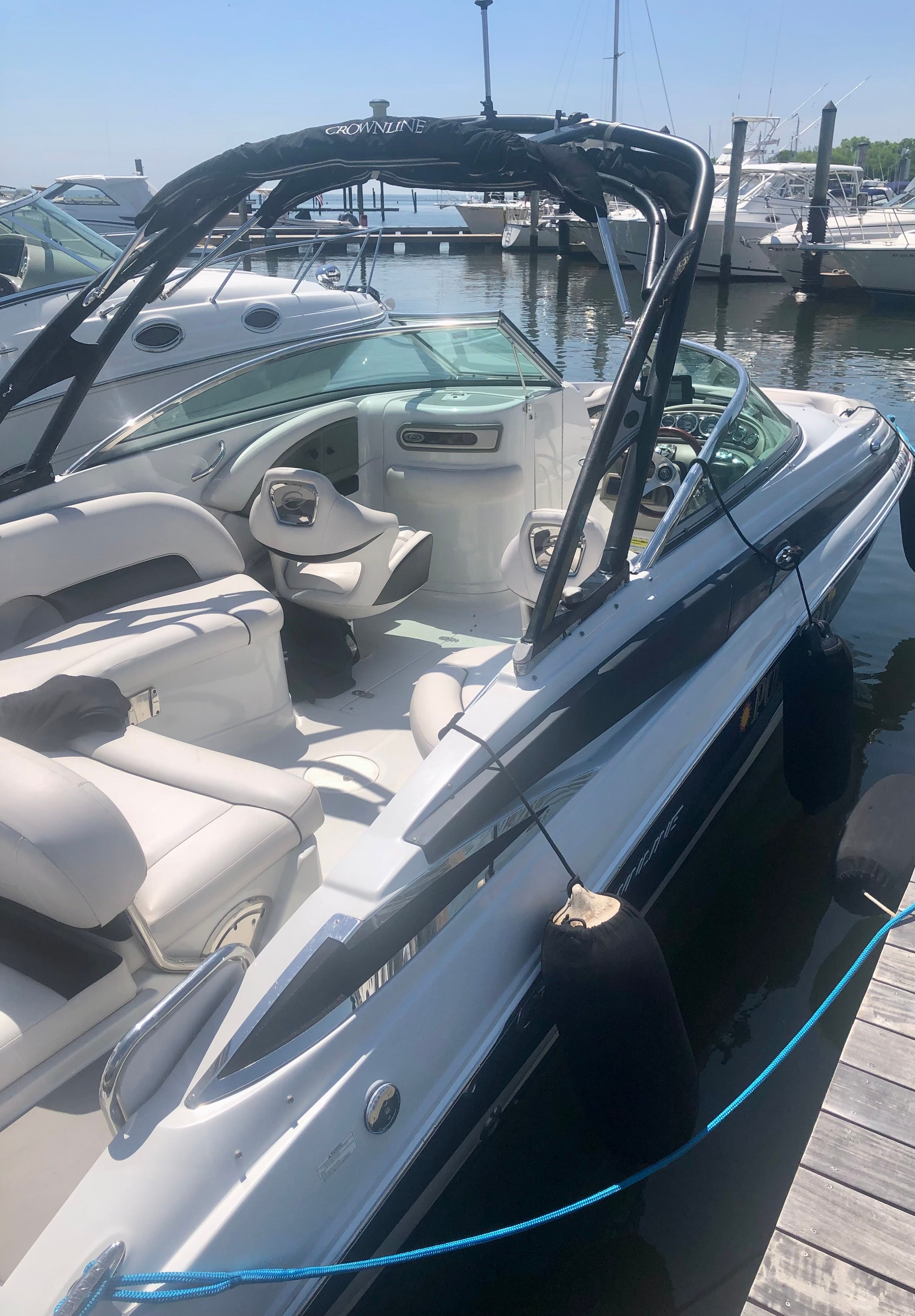 A 2013 Crownline E-4 Bowrider docked. It features sleek design and comfortable seating.