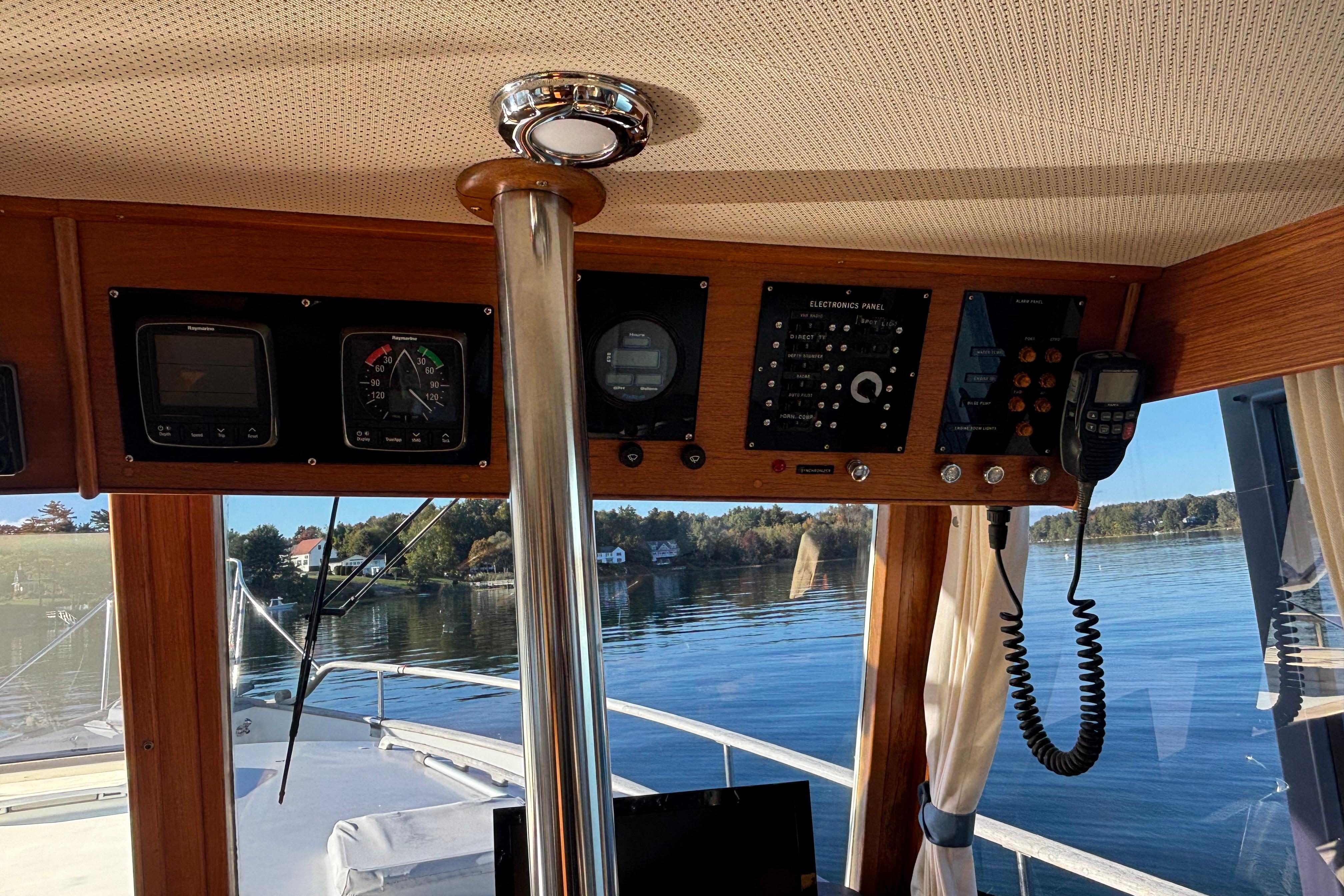 Interior view of 1989 Grand Banks 46 Classic yacht with control panel and scenic waterway.