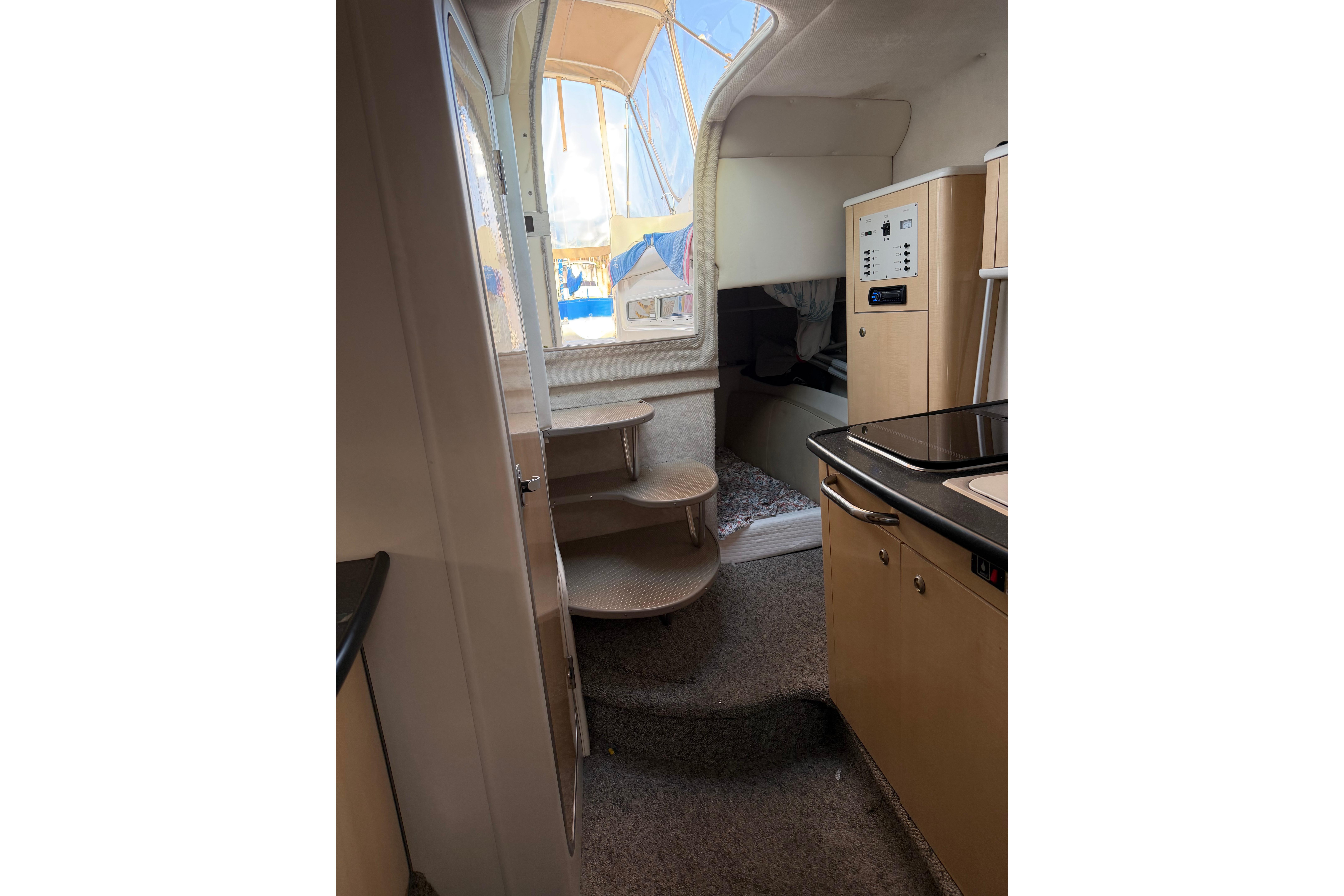 Interior view of 2001 Maxum 2800 SCR boat, featuring compact kitchen and stairs.