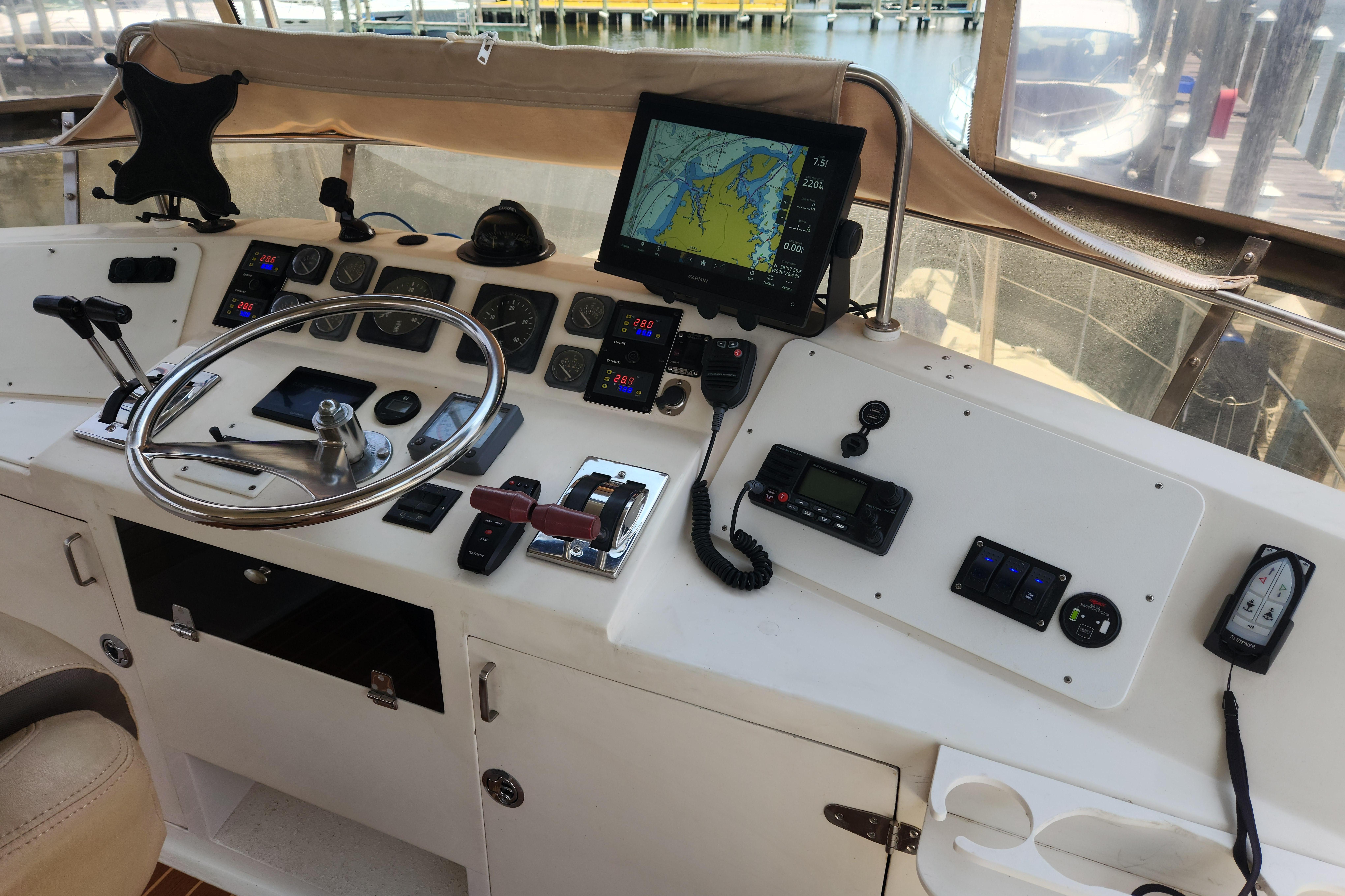 Control panel of a 1989 Hyatt Double Cabin Motoryacht with navigation equipment and steering wheel.