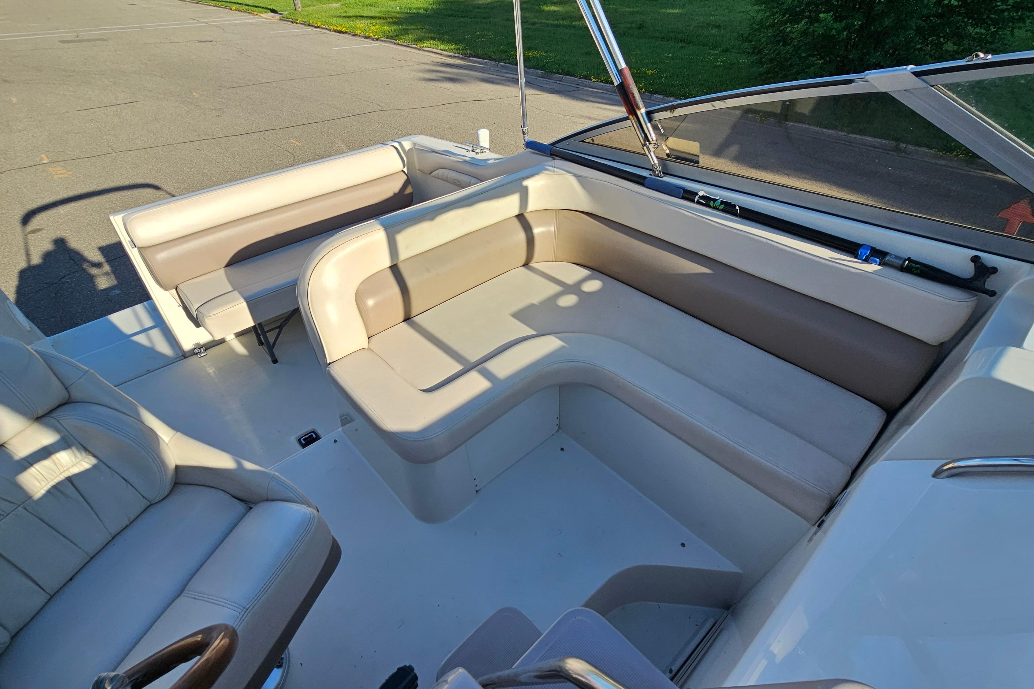 1999 Regal Commodore 258 boat interior with beige seating and fishing rod on deck.