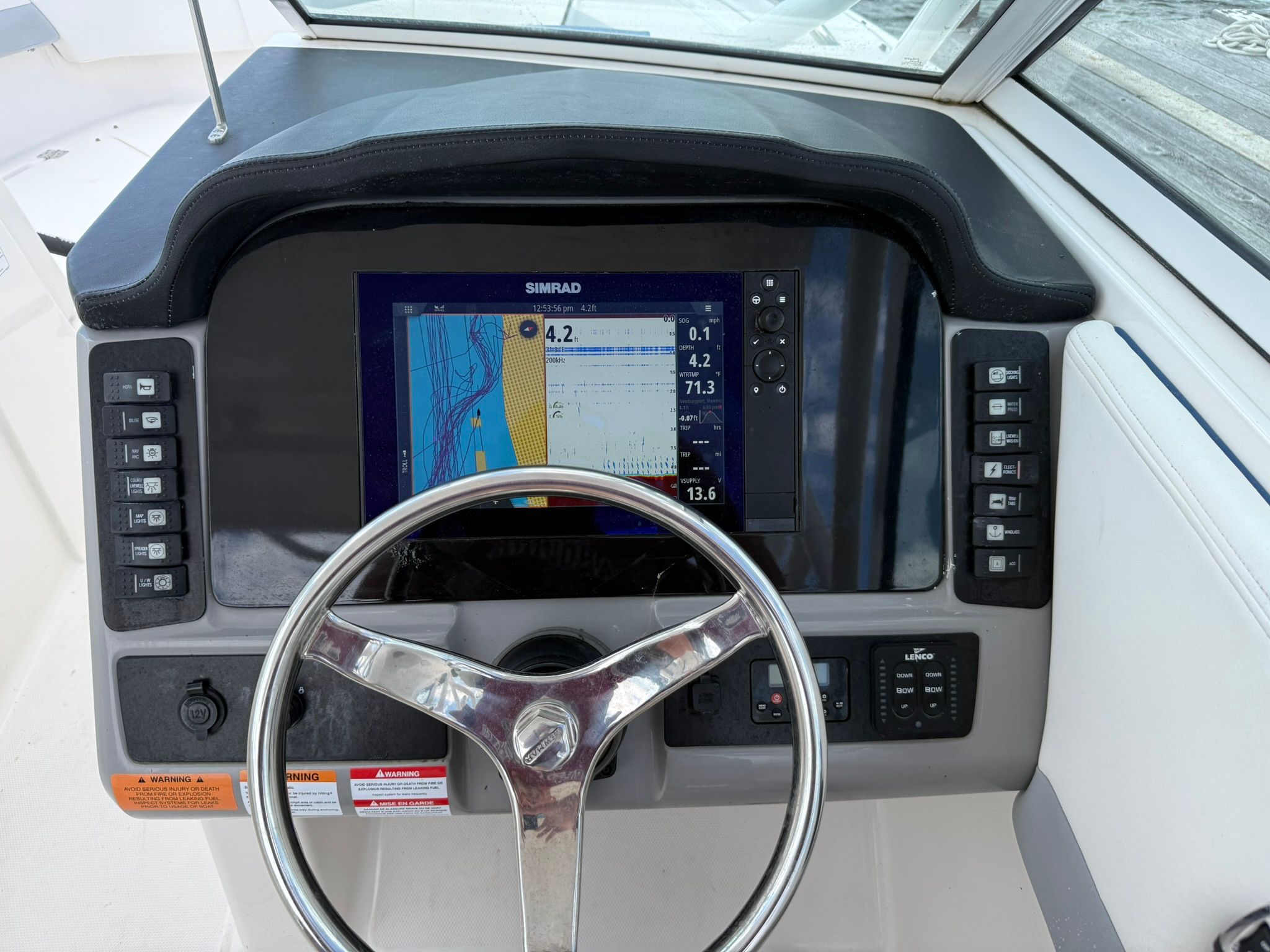 The image shows the helm of a 2022 Robalo R247 Dual Console boat with a Simrad display.