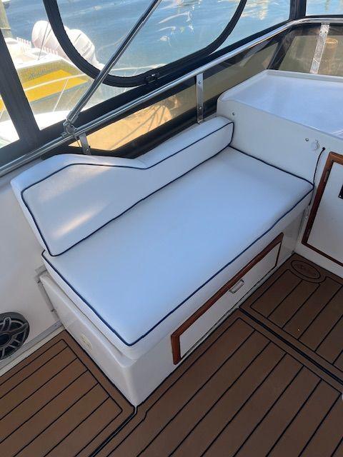 1990 Jefferson 42 Viscount Sundeck interior with white cushioned seating and wood accents.