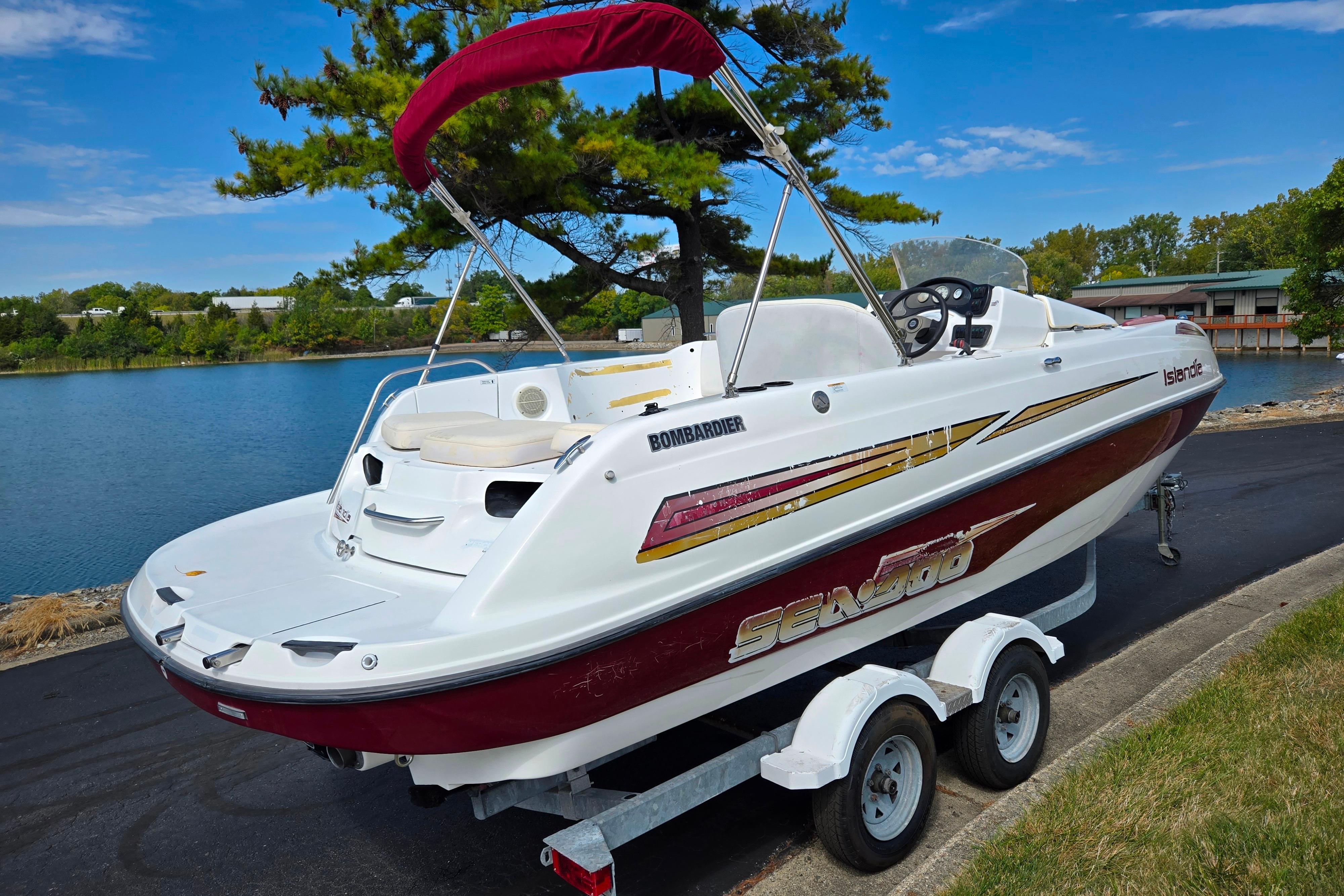 2004 Sea-Doo Islandia sport boat on trailer by a scenic lake.